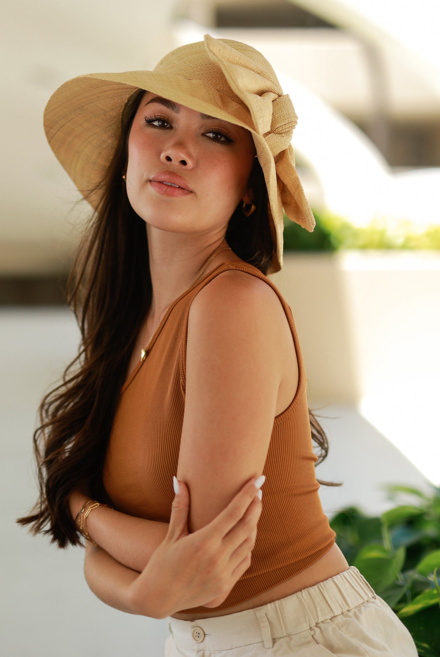 Model wearing Cara Natural straw color big bow embellishment handmade loomed raffia straw bucket style cloche sun hat - Shebobo