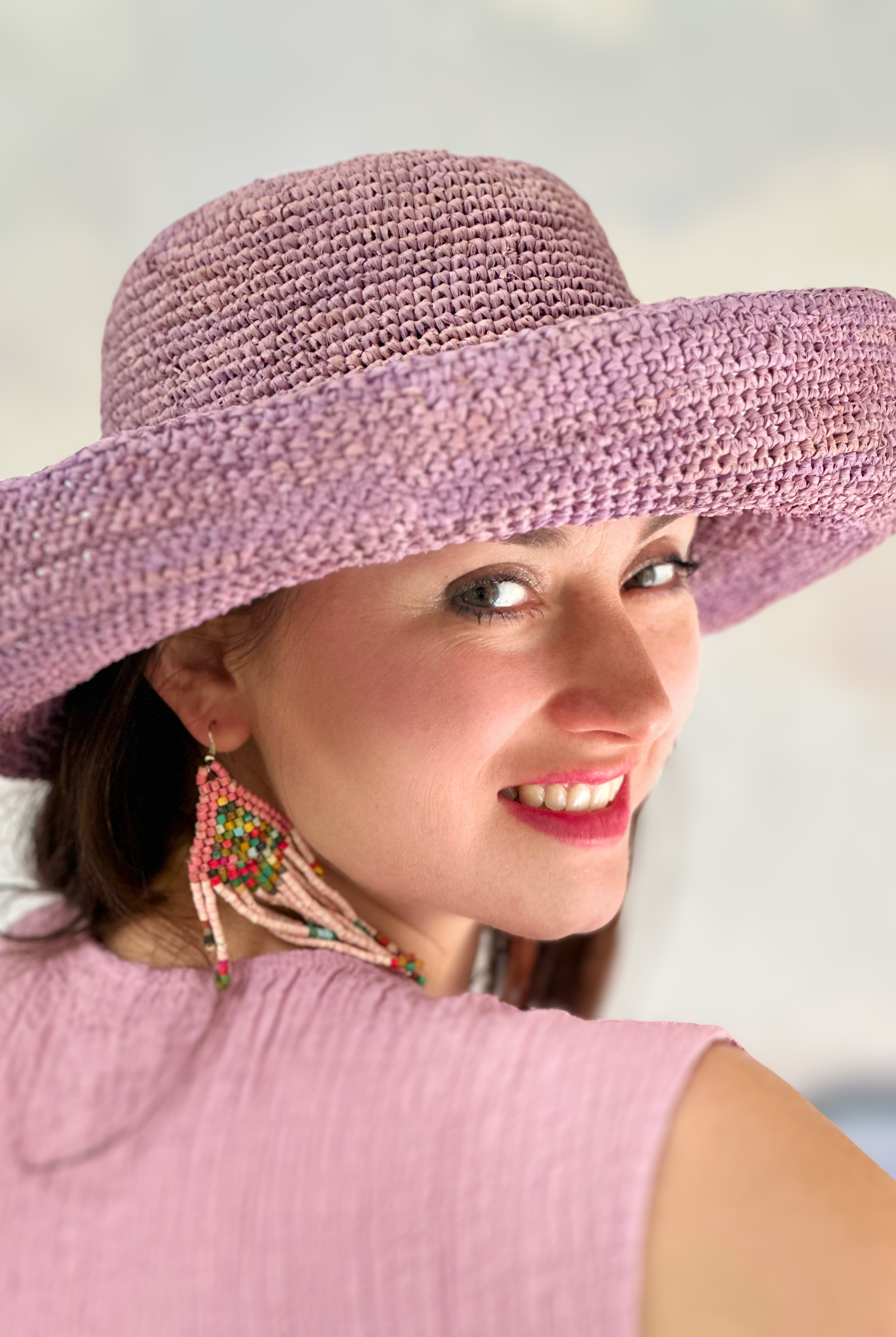 Model wearing Leor Wisteria crochet straw hat handmade wisteria/lilac/lavender/pale purple color raffia 3" brim packable straw hat with matching adjustable braided hat band - Shebobo