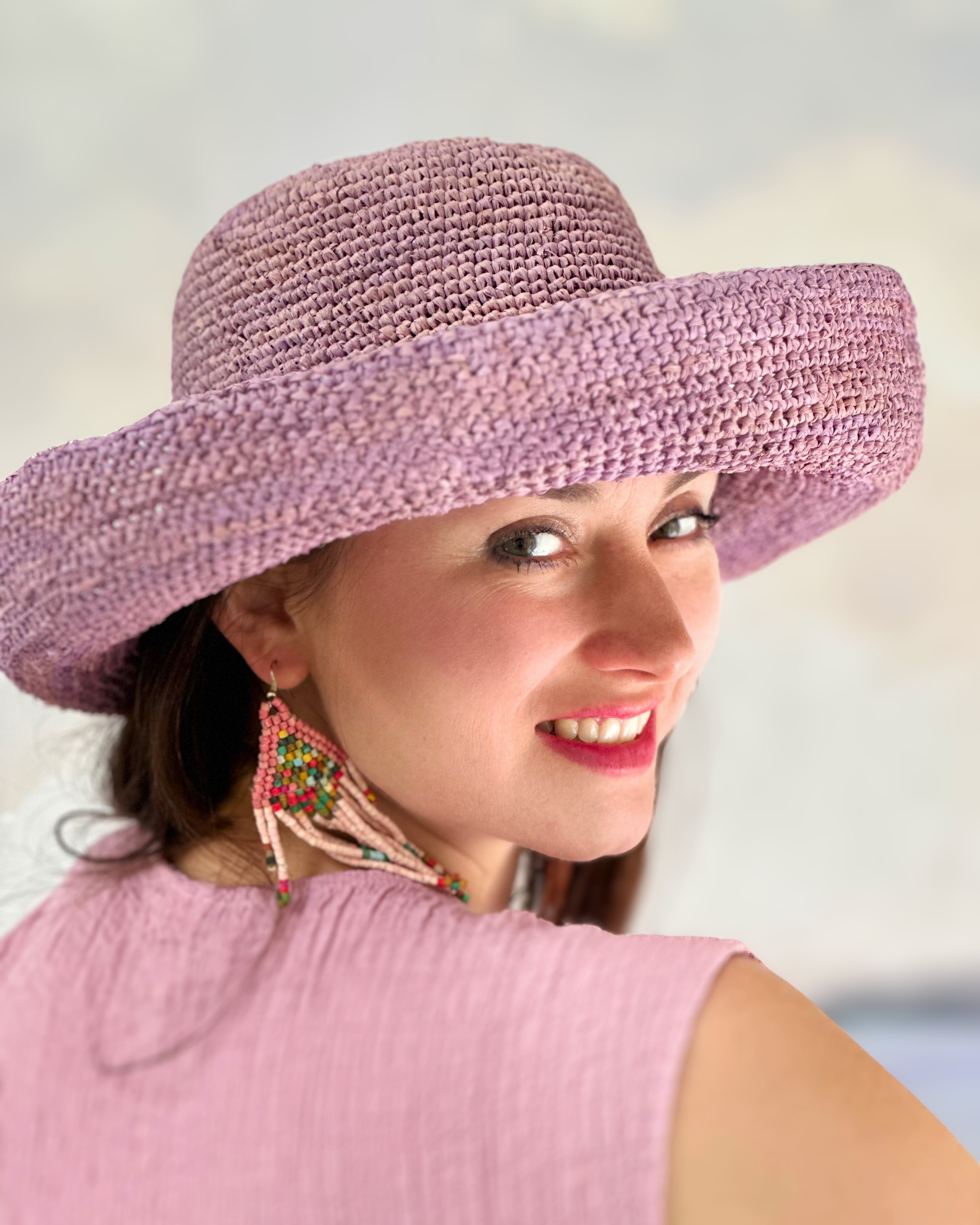Model wearing Leor Wisteria crochet straw hat handmade wisteria/lilac/lavender/pale purple color raffia 3" brim packable straw hat with matching adjustable braided hat band - Shebobo