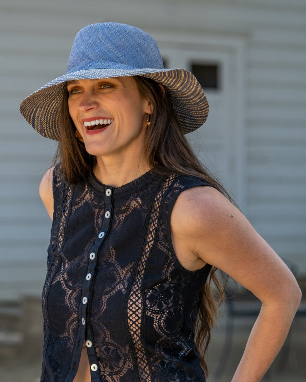 Model wearing 3" Brim Marsea Denim Two Tone Melange Straw Sun Hats handmade loomed natural raffia palm fiber in a two tone color block aesthetic of solid denim retro/light/ blue on the crown and hatband with multicolor melange heathered pattern swirl of denim and natural straw color on the brim lightweight breathable packable hat - Shebobo