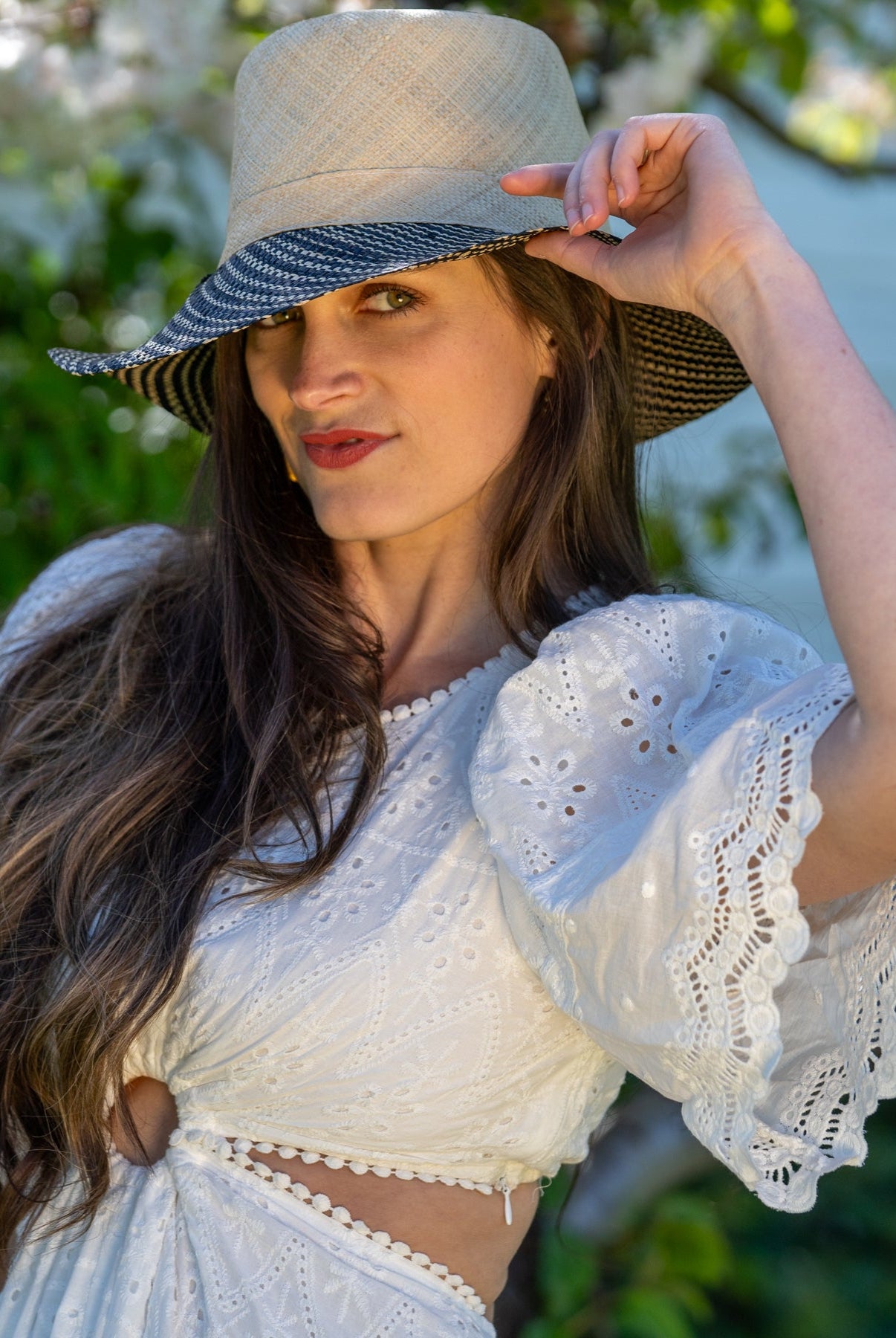 Model wearing 3" Brim Marsea Natural Two Tone Melange Straw Sun Hats handmade loomed natural raffia palm fiber in a two tone color block aesthetic of solid natural straw color on the crown and hatband with multicolor melange heathered pattern swirl of black and natural straw color on the brim lightweight breathable packable hat - Shebobo
