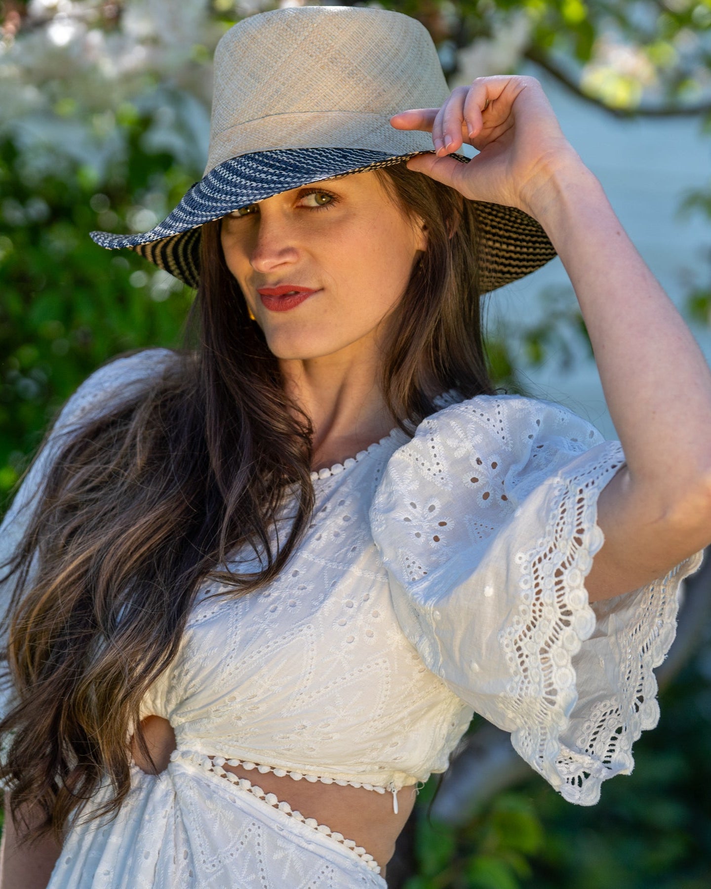Model wearing 3" Brim Marsea Natural Two Tone Melange Straw Sun Hats handmade loomed natural raffia palm fiber in a two tone color block aesthetic of solid natural straw color on the crown and hatband with multicolor melange heathered pattern swirl of black and natural straw color on the brim lightweight breathable packable hat - Shebobo
