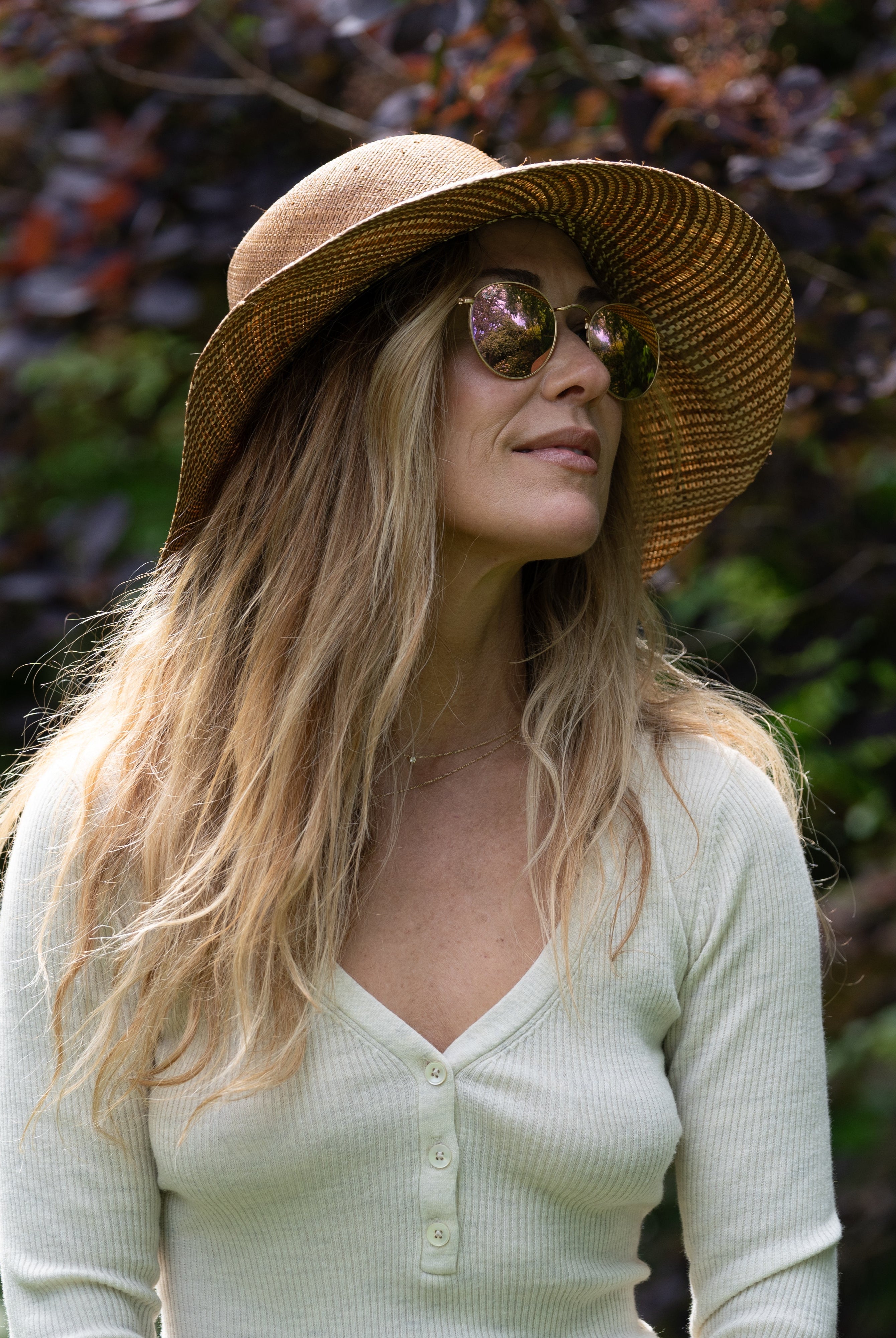 Model wearing 3" Brim Marsea Cinnamon Two Tone Melange Straw Sun Hats handmade loomed natural raffia palm fiber in a two tone color block aesthetic of solid cinnamon tobacco/dark/brown on the crown and hatband with multicolor melange heathered pattern swirl of cinnamon and natural straw color on the brim lightweight breathable packable hat - Shebobo