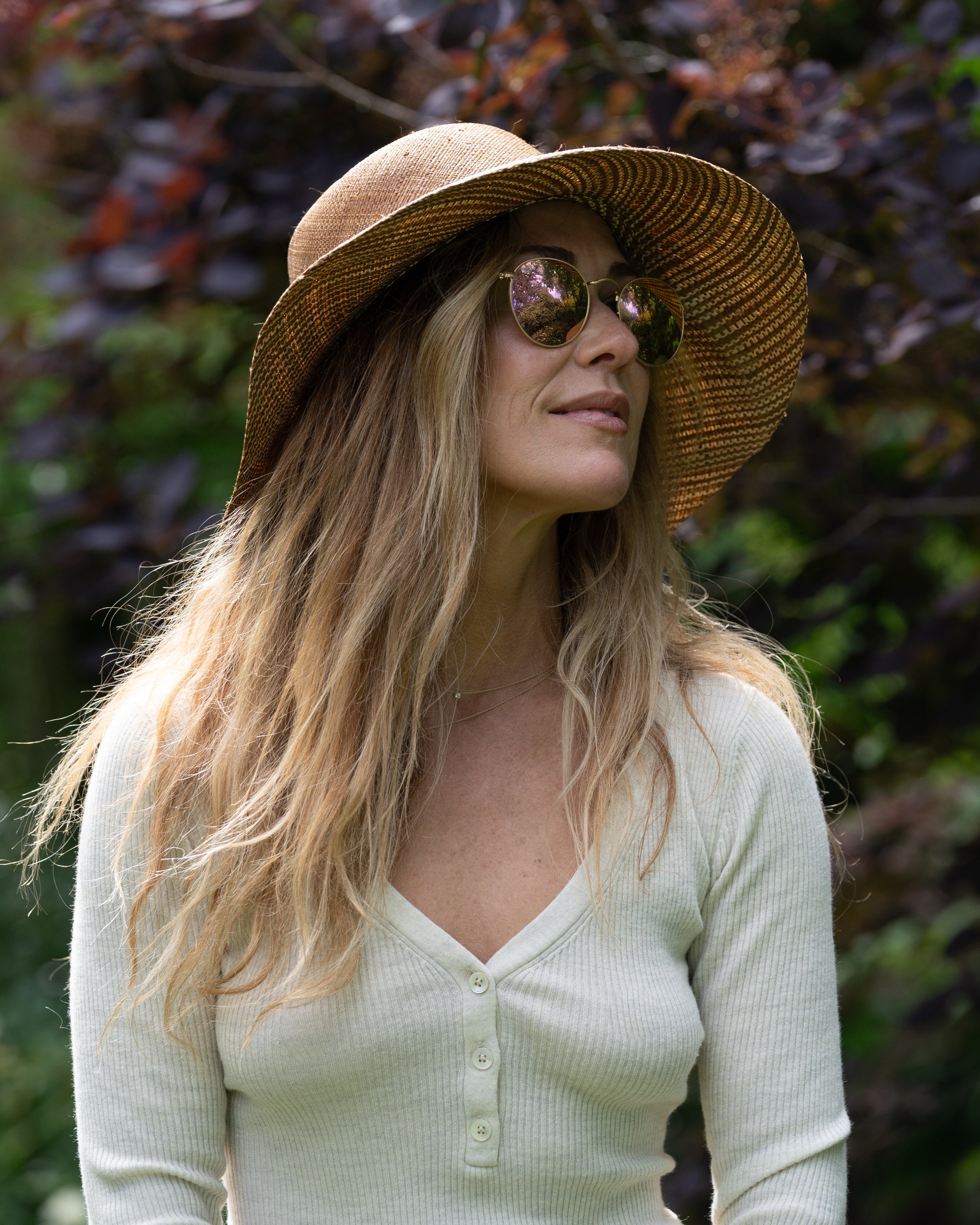Model wearing 3" Brim Marsea Cinnamon Two Tone Melange Straw Sun Hats handmade loomed natural raffia palm fiber in a two tone color block aesthetic of solid cinnamon tobacco/dark/brown on the crown and hatband with multicolor melange heathered pattern swirl of cinnamon and natural straw color on the brim lightweight breathable packable hat - Shebobo