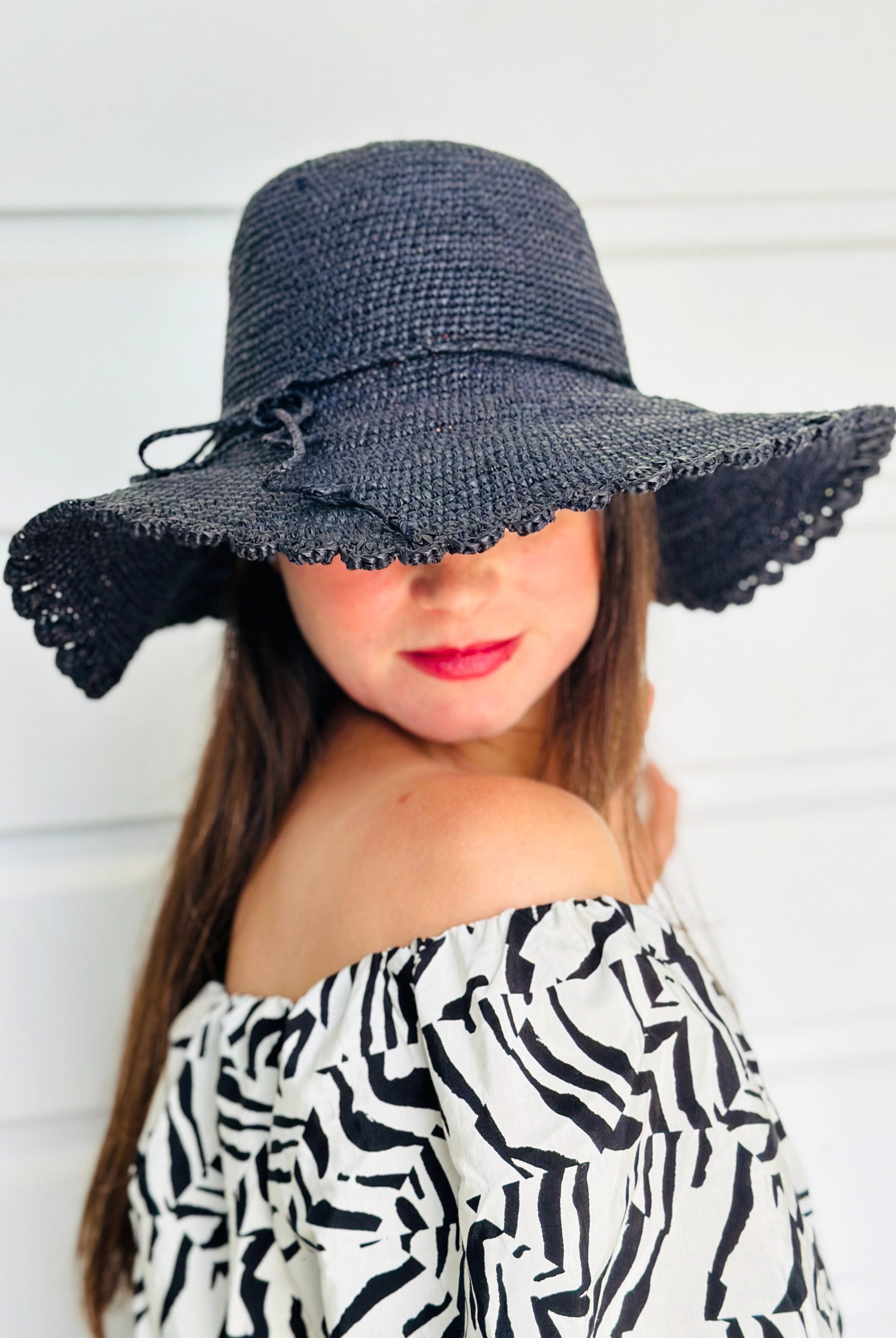 Model wearing 4" Brim Genevieve Black Crochet Straw Sun Hat with Lace Weave Edge handmade raffia palm fiber crochet solid hue black rounded crown with detailed lace weave edge and matching adjustable hat band - Shebobo