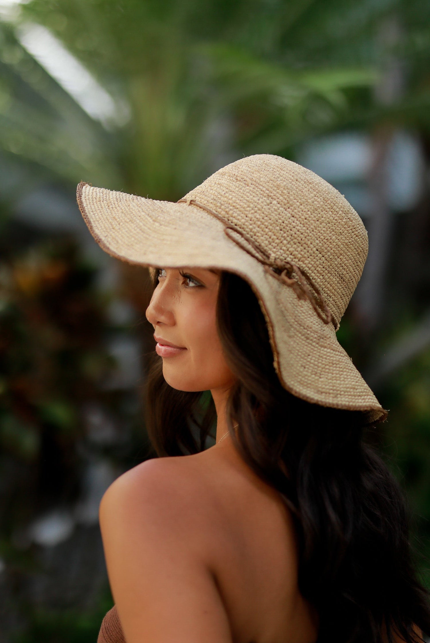 Model wearing 4" Brim Rachel Cinnamon Crochet Straw Sun Hat handmade crochet natural raffia palm fiber hat with dark brown/cinnamon/tobacco edge and matching corded hat band - Shebobo