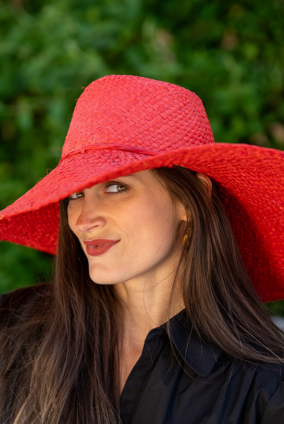 Model wearing 7" Wide Brim Natasha Red Woven XL Straw Sun Hat handmade woven natural raffia palm fiber in a solid hue of red with matching adjustable twisted raffia hat band and and extra wide brim - Shebobo