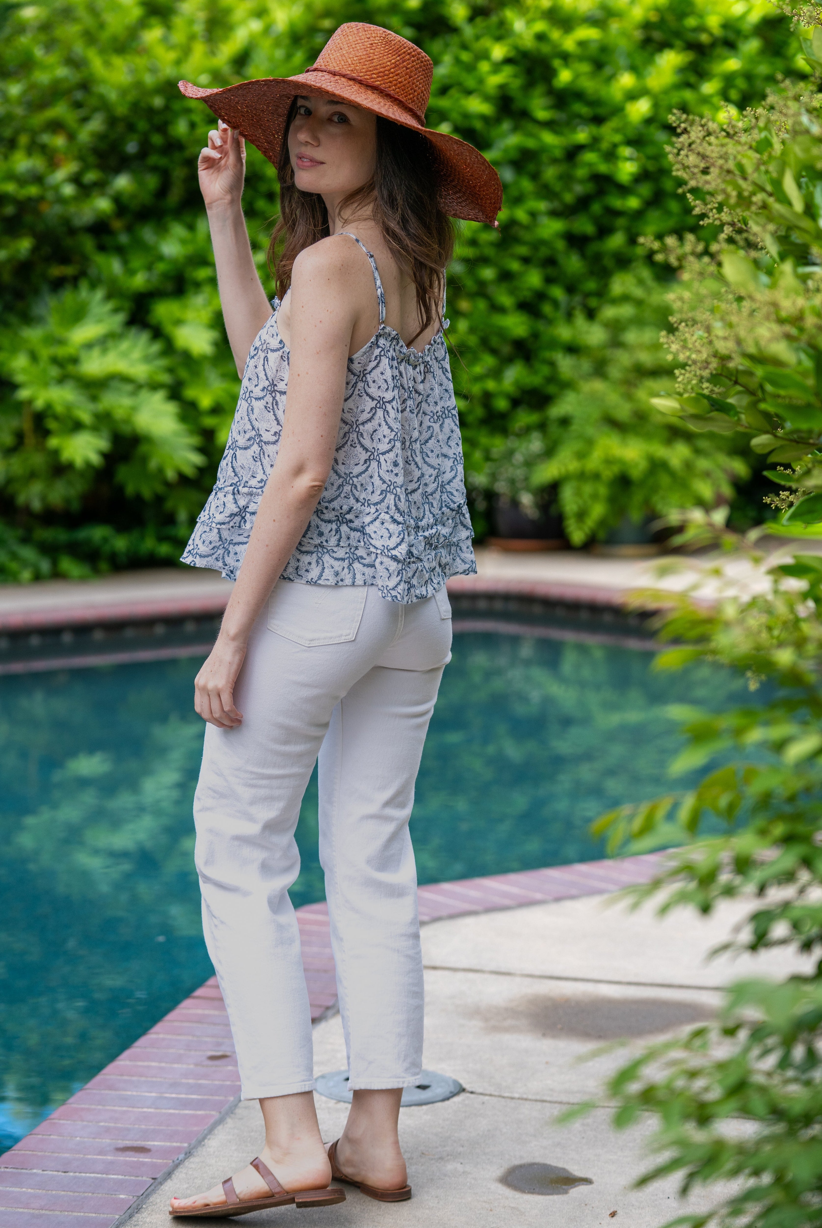 Model wearing 7" Wide Brim Natasha Caramel Woven XL Straw Sun Hat handmade woven natural raffia palm fiber in a solid hue of whisky red/brown with matching adjustable twisted raffia hat band and and extra wide brim - Shebobo