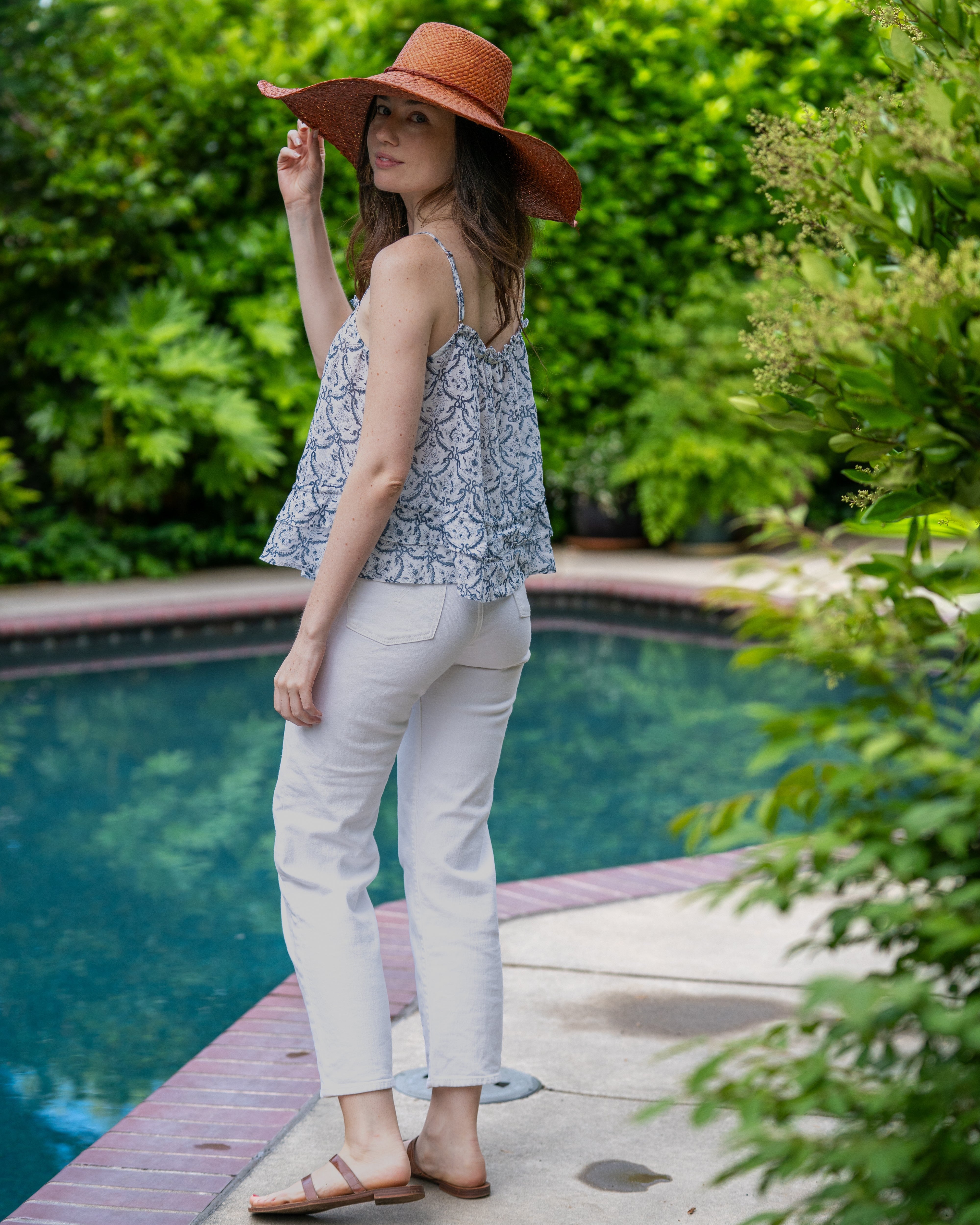 Model wearing 7" Wide Brim Natasha Caramel Woven XL Straw Sun Hat handmade woven natural raffia palm fiber in a solid hue of whisky red/brown with matching adjustable twisted raffia hat band and and extra wide brim - Shebobo