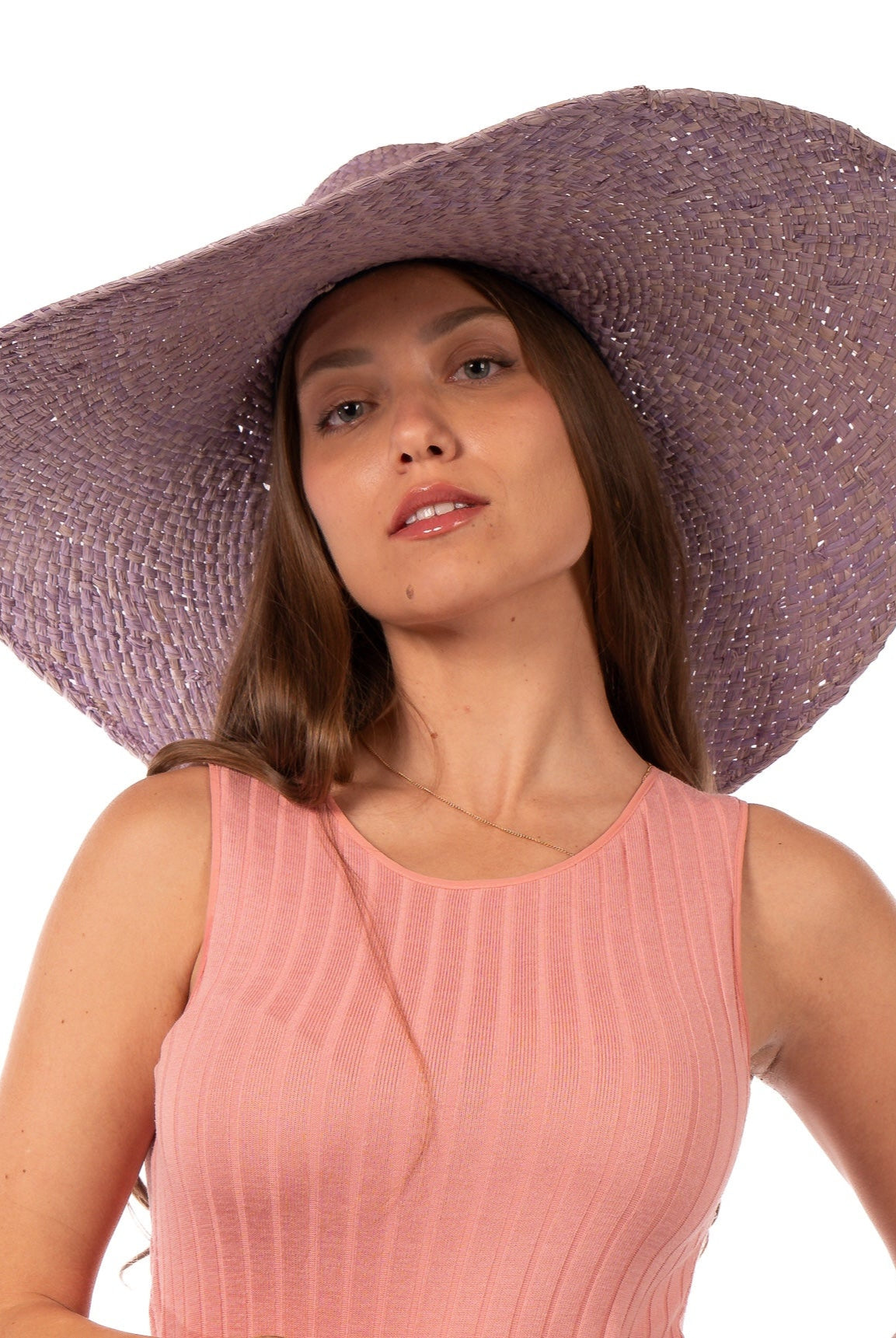 Model wearing 7" Wide Brim Natasha Wisteria Woven XL Straw Sun Hat handmade woven natural raffia palm fiber in a solid hue of wisteria/lavender/lilac pink/purple with matching adjustable twisted raffia hat band and and extra wide brim - Shebobo