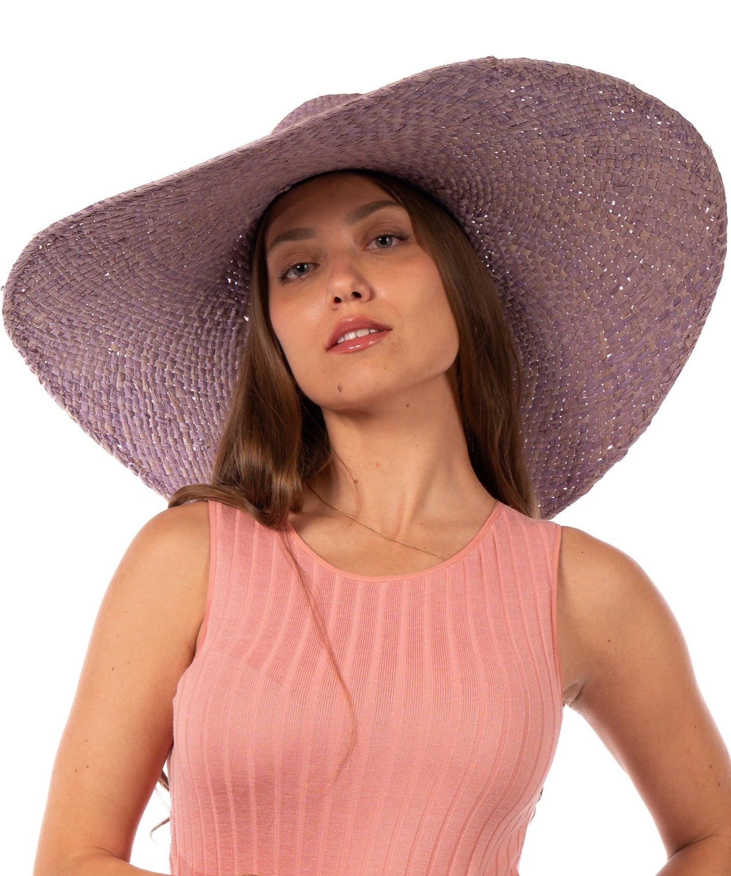 Model wearing 7" Wide Brim Natasha Wisteria Woven XL Straw Sun Hat handmade woven natural raffia palm fiber in a solid hue of wisteria/lavender/lilac pink/purple with matching adjustable twisted raffia hat band and and extra wide brim - Shebobo