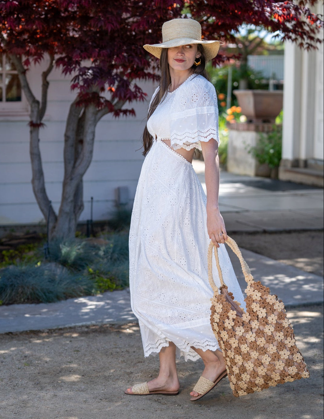 Model wearing Model wearing Amalie Two Tone Daisy Flower Crochet Straw Handbag handmade crochet mini flower buds from crochet natural raffia palm fiber in an alternating colored pattern of cappuccino tea/light/brown and natural straw color with brown internal liner and natural woven handles purse - Shebobo (with Bolero 3" Brim Crochet Straw Sun Hats)