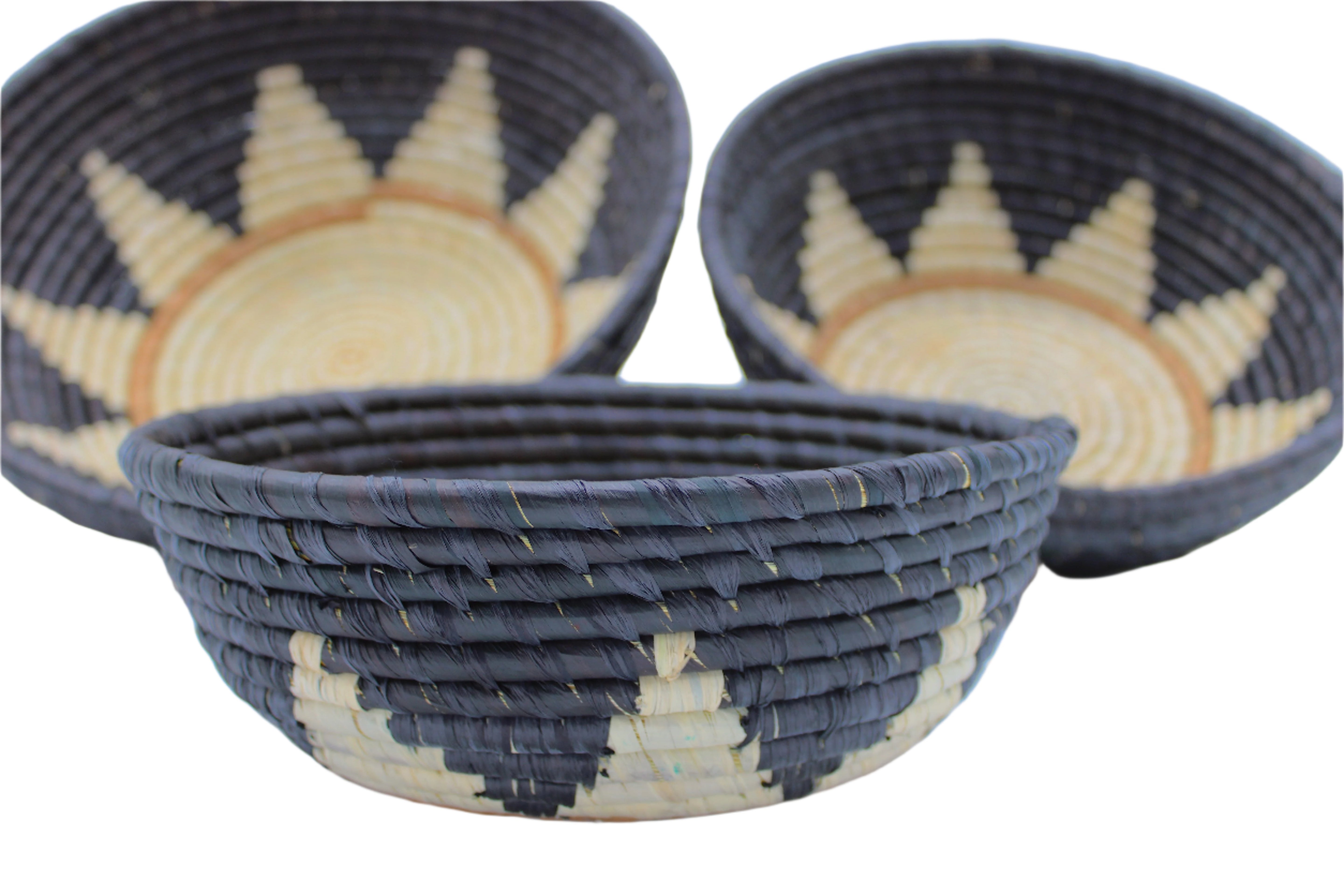 Side view Amara Raffia Straw Decor Display Basket Bowls: Set of 3 handmade woven natural raffia palm fiber in a crochet loop technique concentric coiled circular pattern with natural straw color centered in the bottom with brown ring around the bottom of the bowl and natural sunburst floral design pattern up the otherwise black sides of the bowls set of small, medium, and large straw display bowls - Shebobo