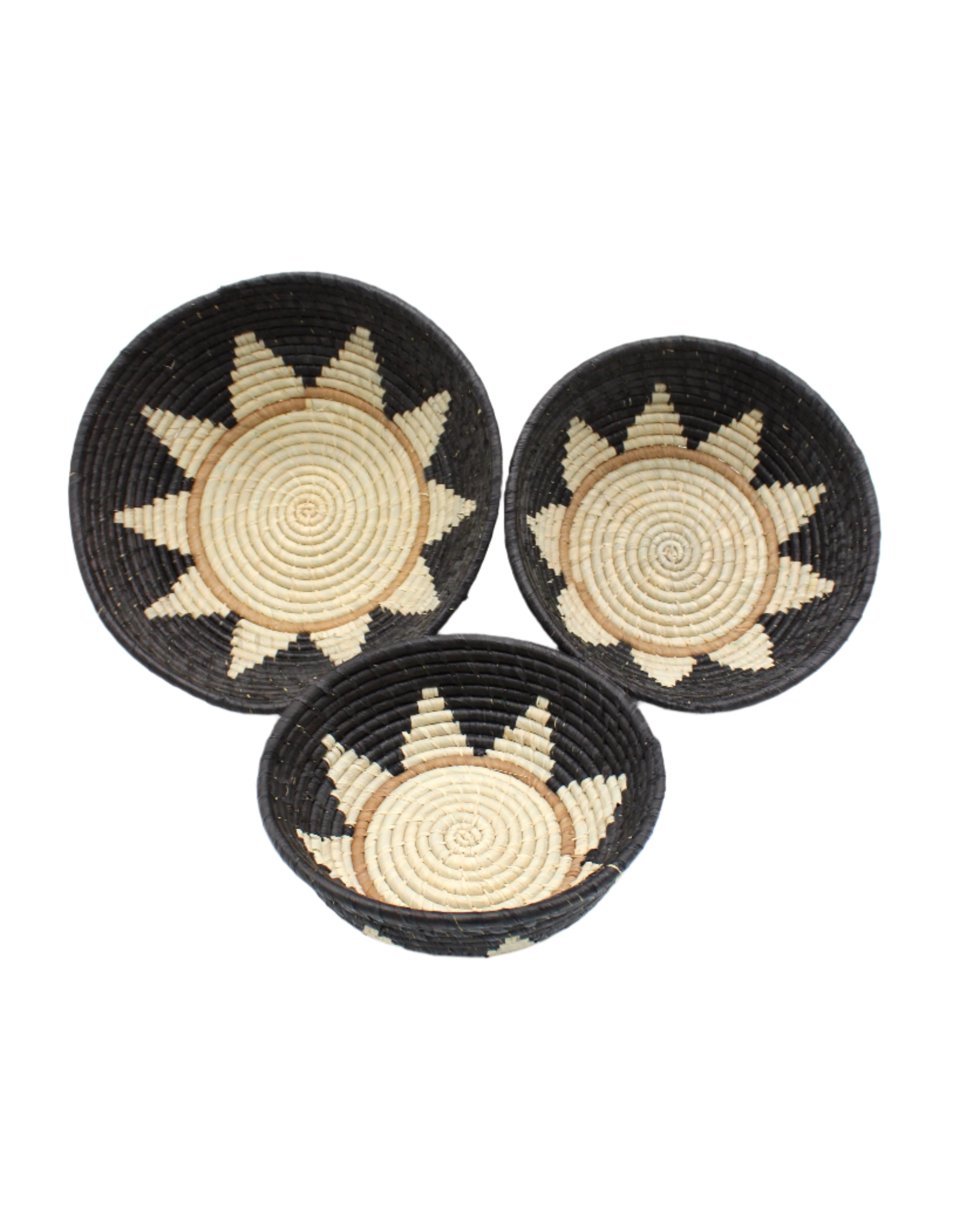 Amara Raffia Straw Decor Display Basket Bowls: Set of 3 handmade woven natural raffia palm fiber in a crochet loop technique concentric coiled circular pattern with natural straw color centered in the bottom with brown ring around the bottom of the bowl and natural sunburst floral design pattern up the otherwise black sides of the bowls set of small, medium, and large straw display bowls - Shebobo