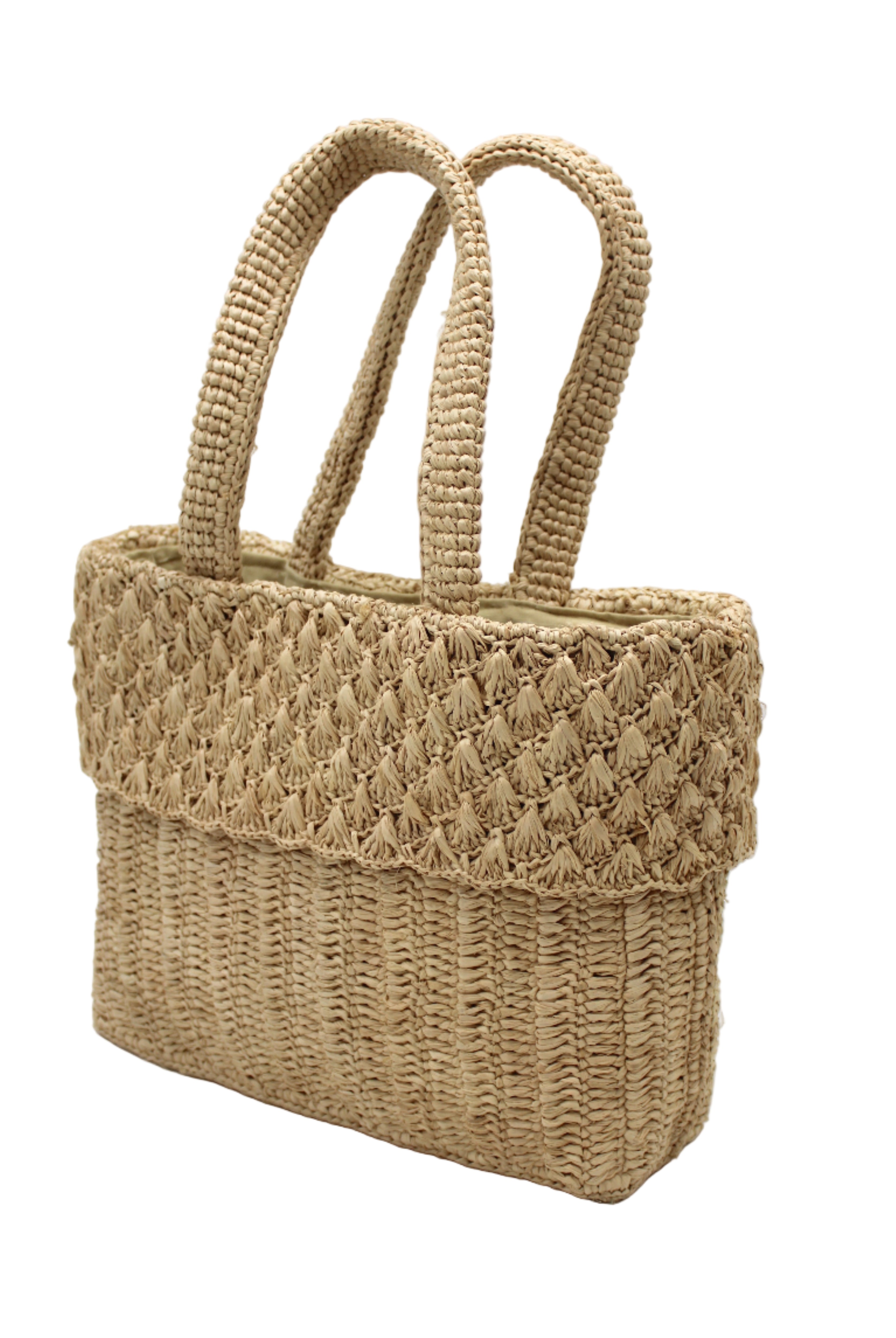 Side view Anna Petal Pattern Crochet Straw Basket Handbag handmade natural raffia palm fiber in a solid hue of Natural straw color crochet in multiple textures resulting in a subtle pattern of vertical linked bands on the bottom 2/3 of the bag, and a floral petal or shell pattern on the upper third with rolled panel of links making up the handles Beach Bag Purse - Shebobo