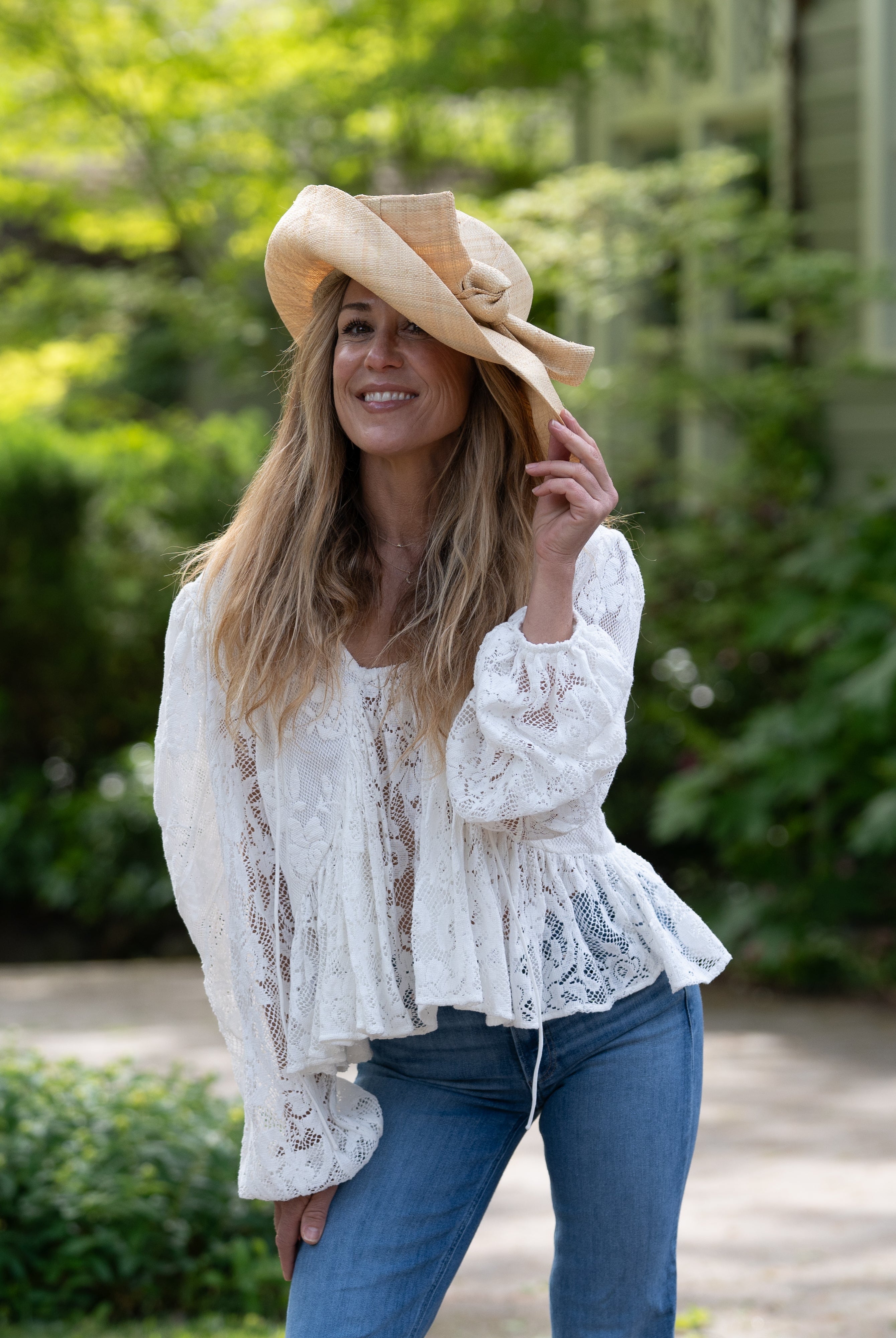 Model wearing Audrey 5" Wide Brim Solid Color Straw Sun Hats with Big Bow handmade loomed natural raffia straw fiber in a solid hue of natural straw color with matching oversized big bow embellishment hat band - Shebobo