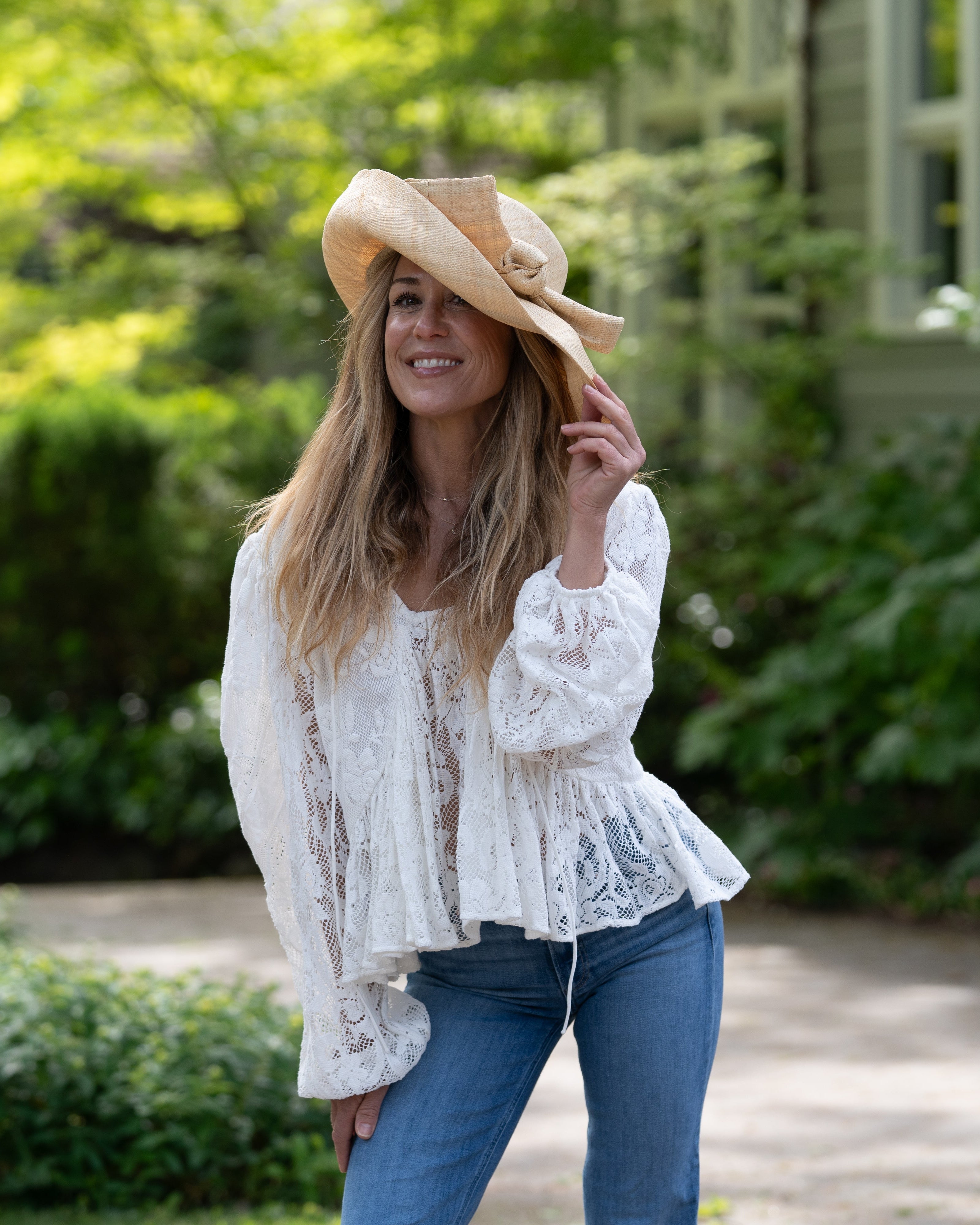 Model wearing Audrey 5" Wide Brim Solid Color Straw Sun Hats with Big Bow handmade loomed natural raffia straw fiber in a solid hue of natural straw color with matching oversized big bow embellishment hat band - Shebobo