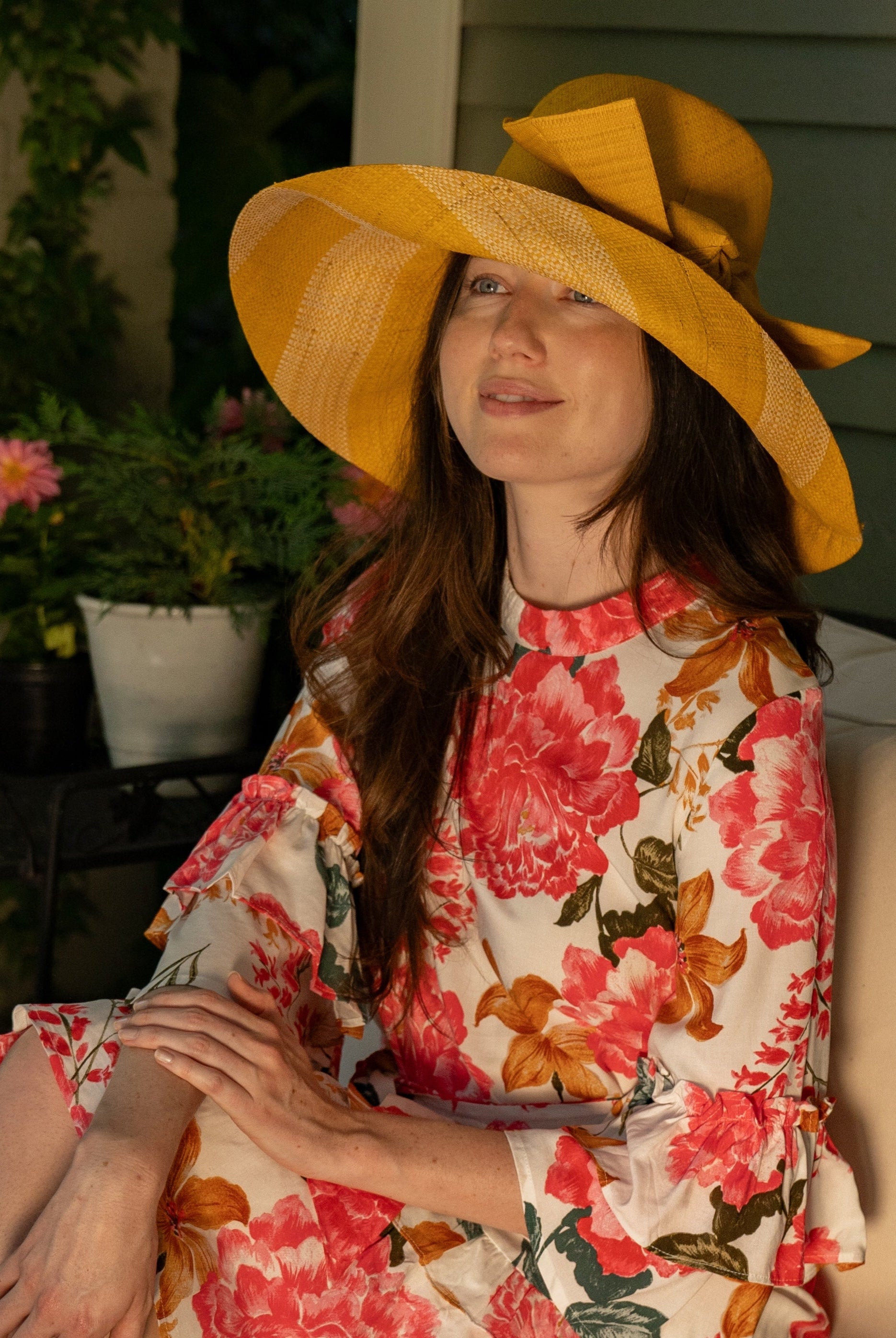 Model wearing Audrey 5" Wide Brim Saffron Two Tone Wide Stripe Straw Sun Hats with Big Bow handmade loomed raffia palm fiber in a solid hue of Saffron yellow/orange on the crown and matching oversized big bow embellishment hat band, with two tone even width wide stripe pattern of saffron and natural straw color that creates a swirl patterned brim - Shebobo