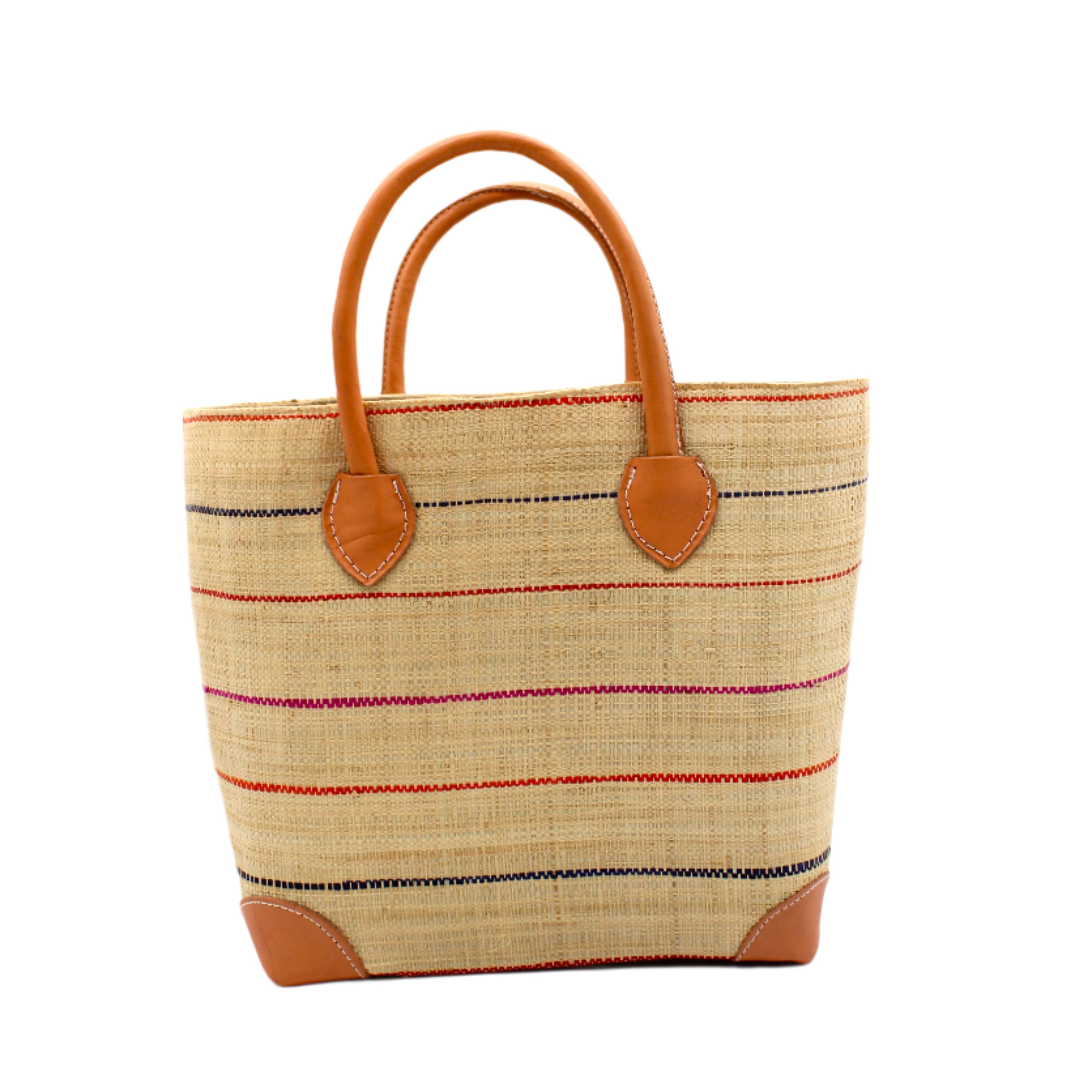 Augustine pinstripes straw basket bag handmade loomed raffia in natural wide horizontal bands with multicolor coral red/orange, fuchsia pink, and navy blue small bands running through in a stripe pattern with leather accents and handles handbag purse - Shebobo