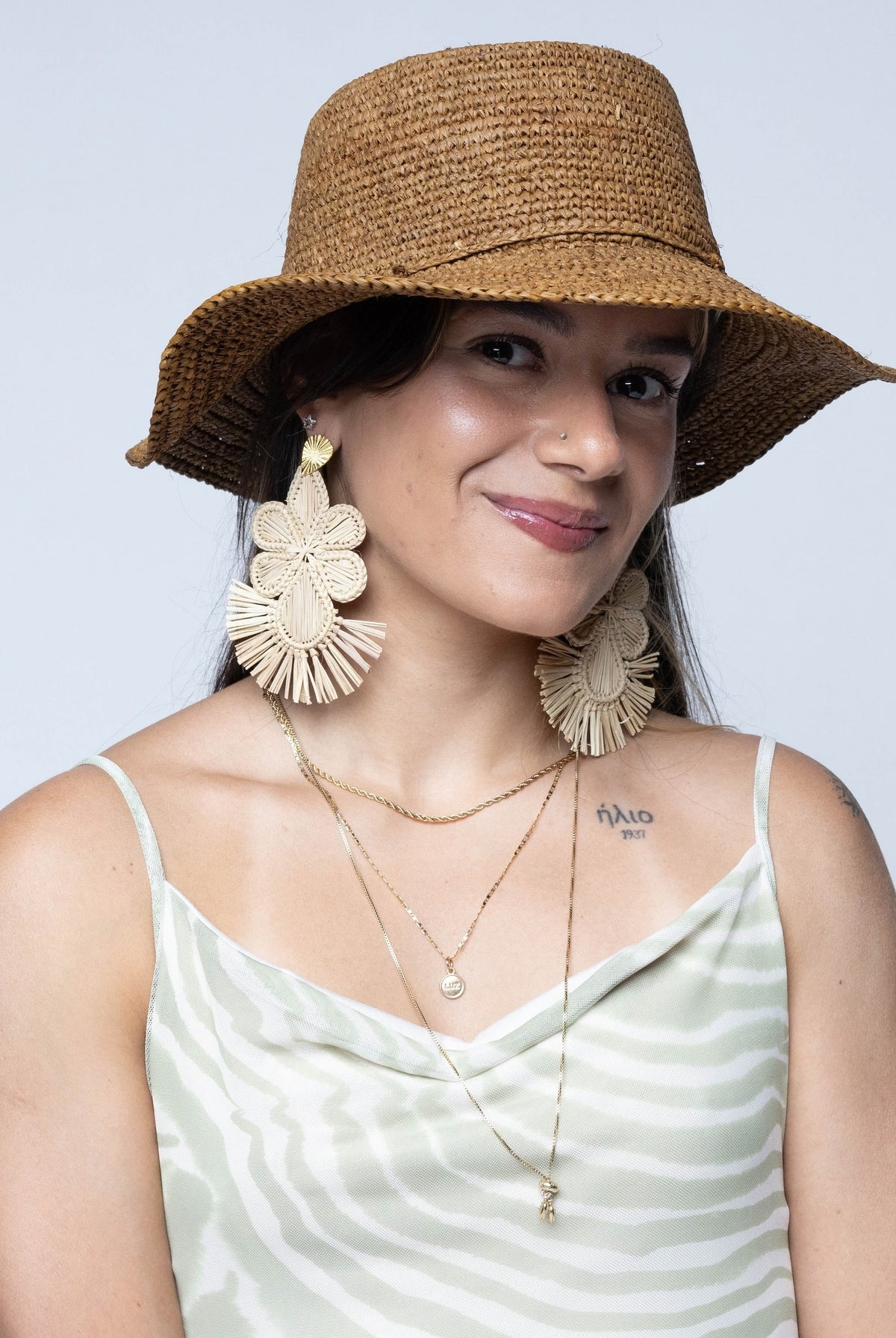 Model wearing 3" Brim Bolero Crochet Straw Sun Hats handmade crochet natural raffia palm fiber in a solid hue of tobacco cinnamon/dark/brown making a concentric pattern from the center top of the flattened crown spiraling out to the edge of the brim with matching adjustable raffia braid hat band - Shebobo