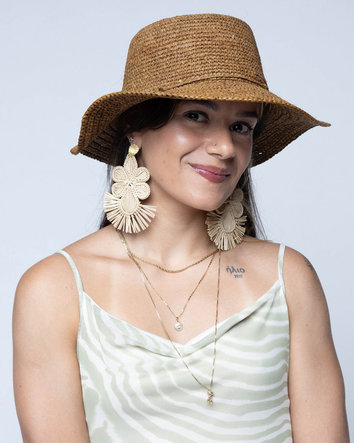 Model wearing 3" Brim Bolero Crochet Straw Sun Hats handmade crochet natural raffia palm fiber in a solid hue of tobacco cinnamon/dark/brown making a concentric pattern from the center top of the flattened crown spiraling out to the edge of the brim with matching adjustable raffia braid hat band - Shebobo