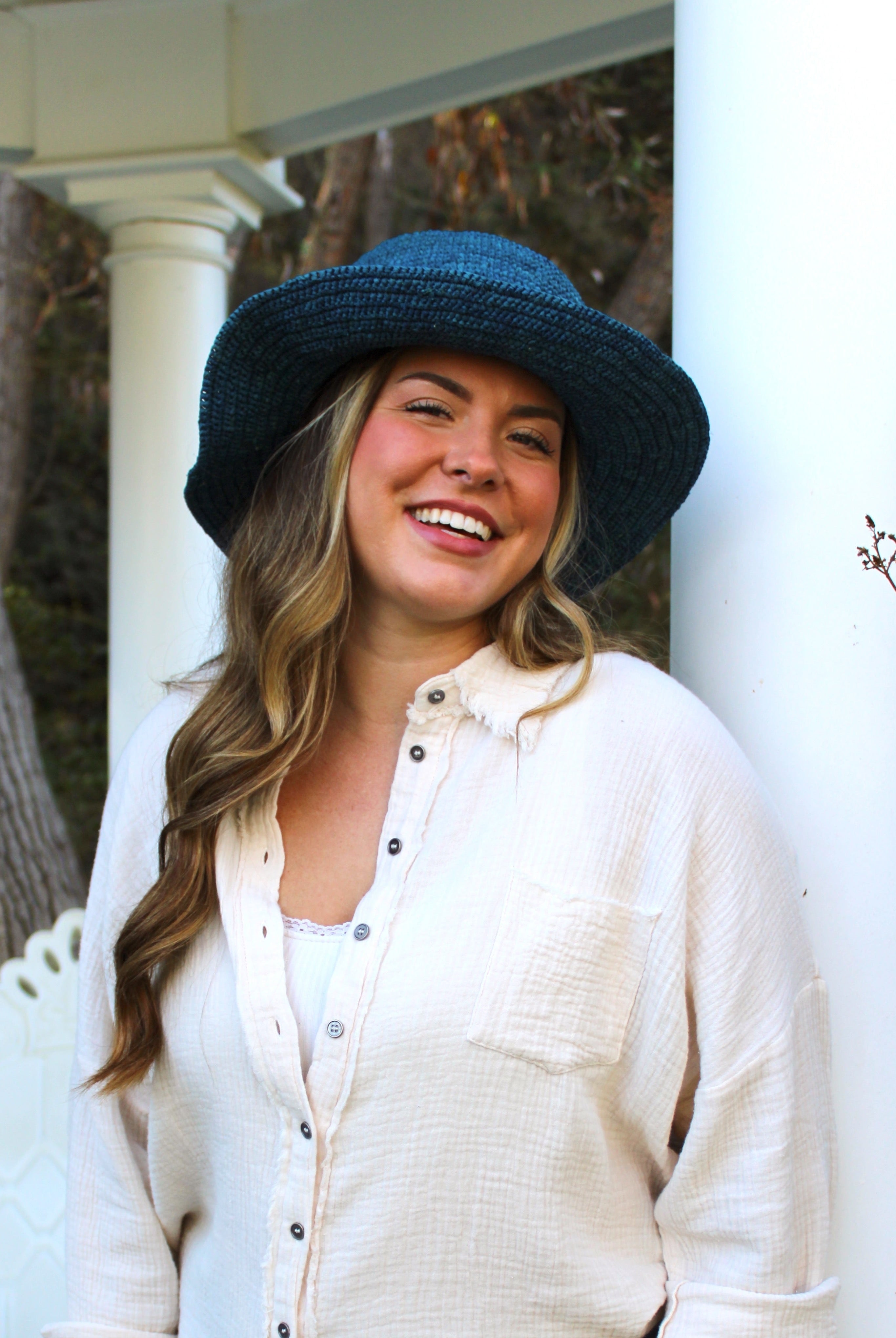 Model wearing 3" Brim Bolero Crochet Straw Sun Hats handmade crochet natural raffia palm fiber in a solid hue of turquoise blue/green making a concentric pattern from the center top of the flattened crown spiraling out to the edge of the brim with matching adjustable raffia braid hat band - Shebobo