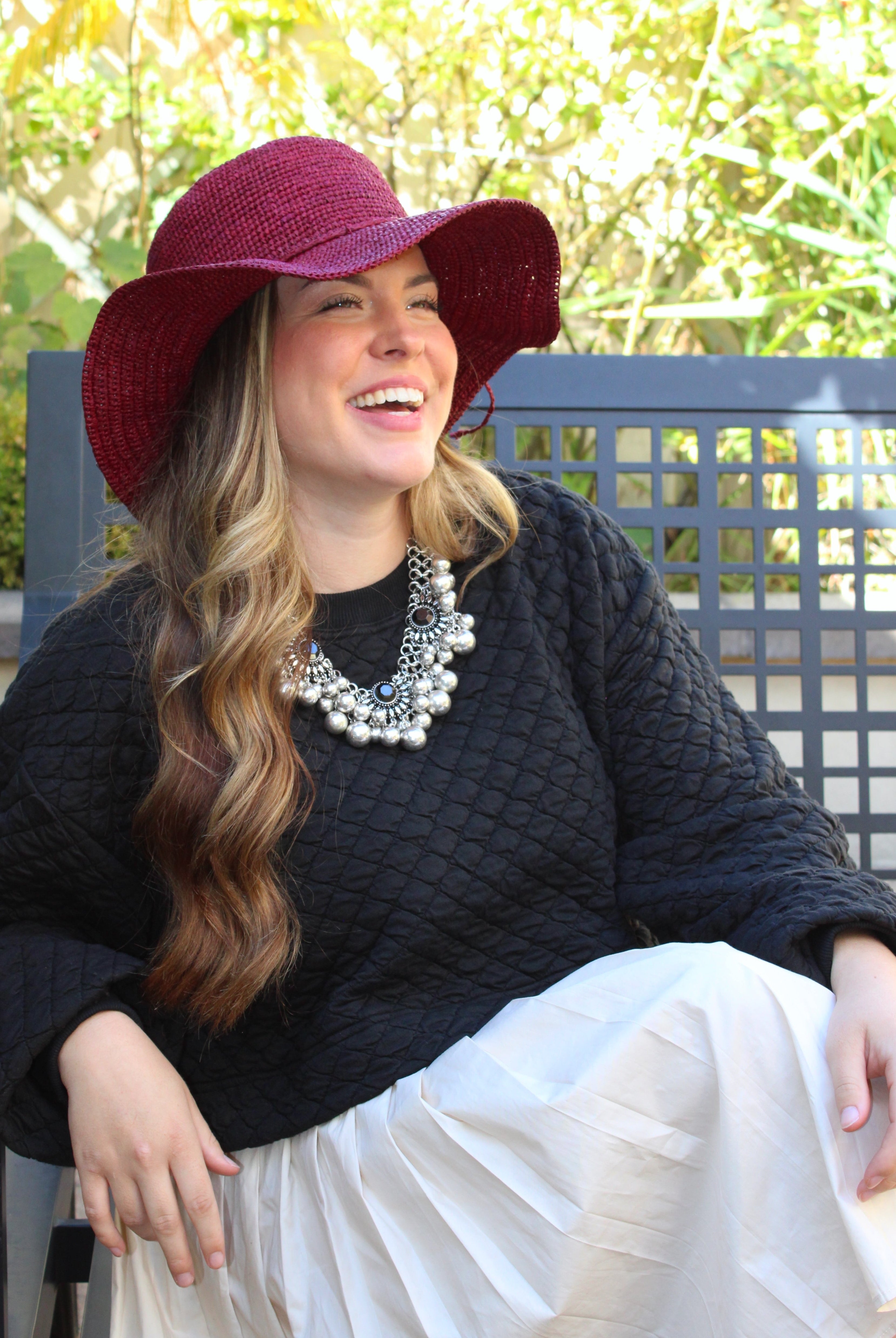 Model wearing 3" Brim Bolero Crochet Straw Sun Hats handmade crochet natural raffia palm fiber in a solid hue of umberwine bordeaux/claret/deep/dark/red/purple making a concentric pattern from the center top of the flattened crown spiraling out to the edge of the brim with matching adjustable raffia braid hat band - Shebobo