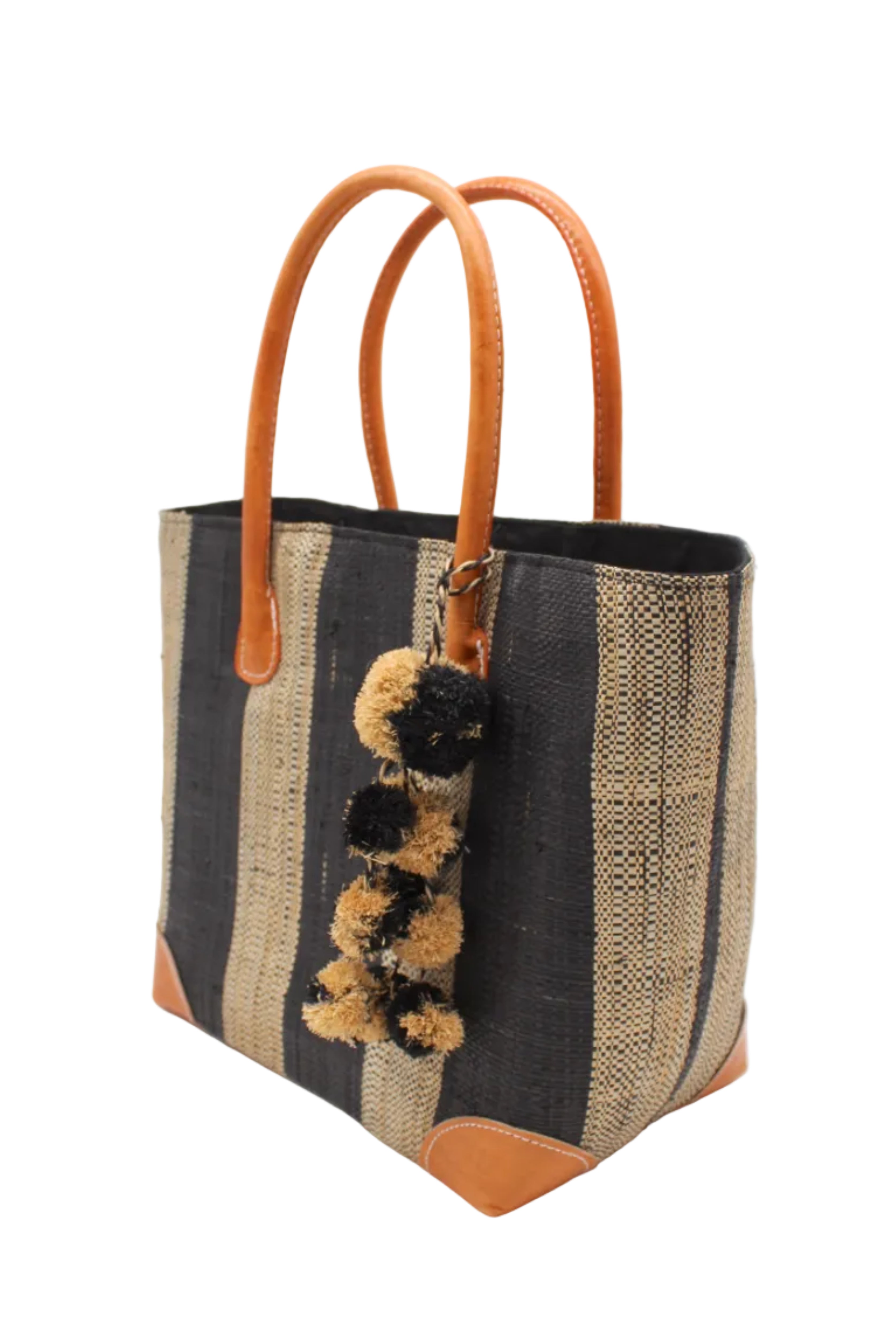 Side view Bora Bora Black Two Tone Stripes Straw Basket Bag with Waterfall Pompoms Charm Embellishment handmade loomed natural raffia palm fiber in a multicolor horizontal stripe pattern of even width wide bands of black and natural straw color with leather handles and feet plus matching waterfall pompom charm embellishment handbag beach bag - Shebobo