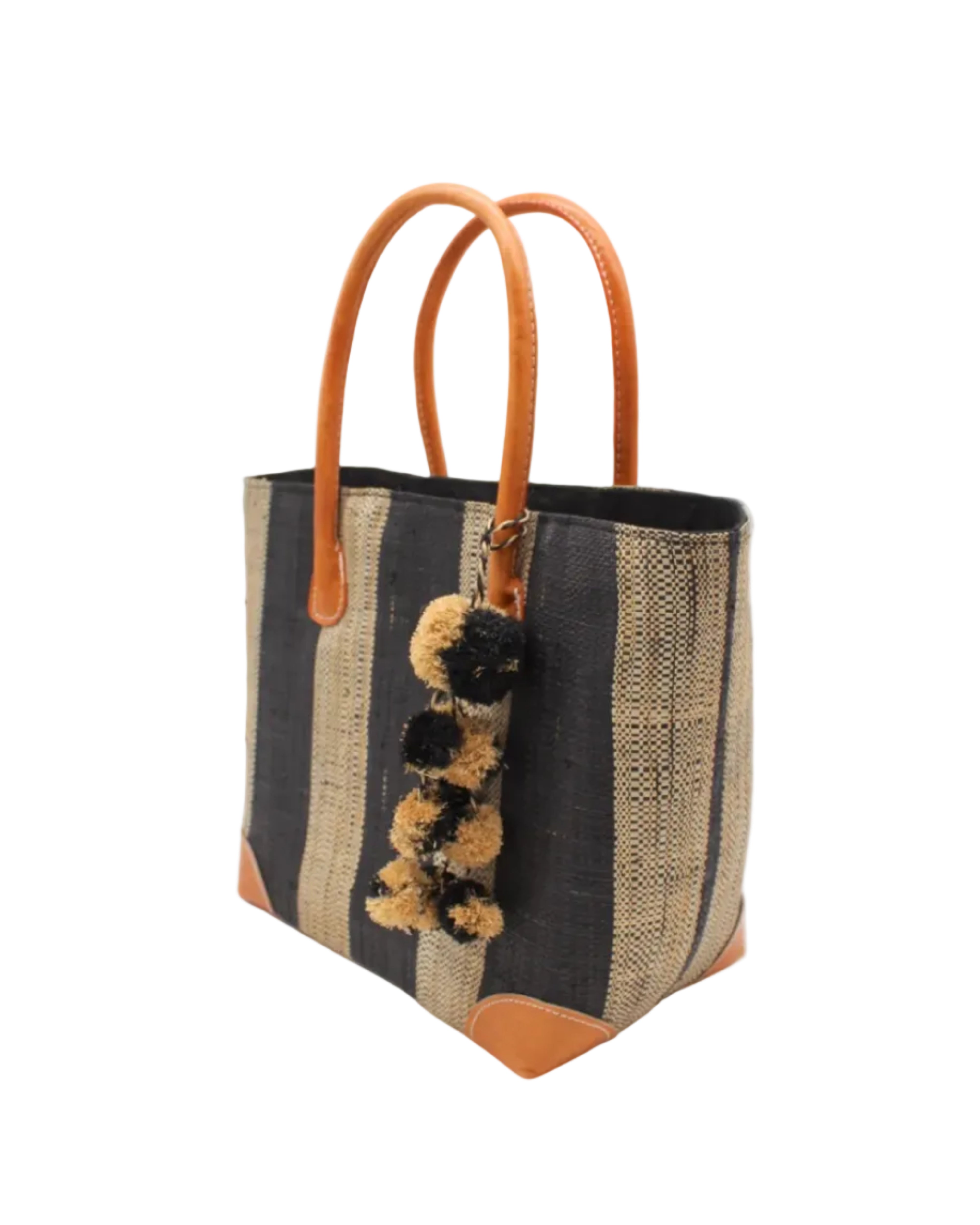 Side view Bora Bora Black Two Tone Stripes Straw Basket Bag with Waterfall Pompoms Charm Embellishment handmade loomed natural raffia palm fiber in a multicolor horizontal stripe pattern of even width wide bands of black and natural straw color with leather handles and feet plus matching waterfall pompom charm embellishment handbag beach bag - Shebobo