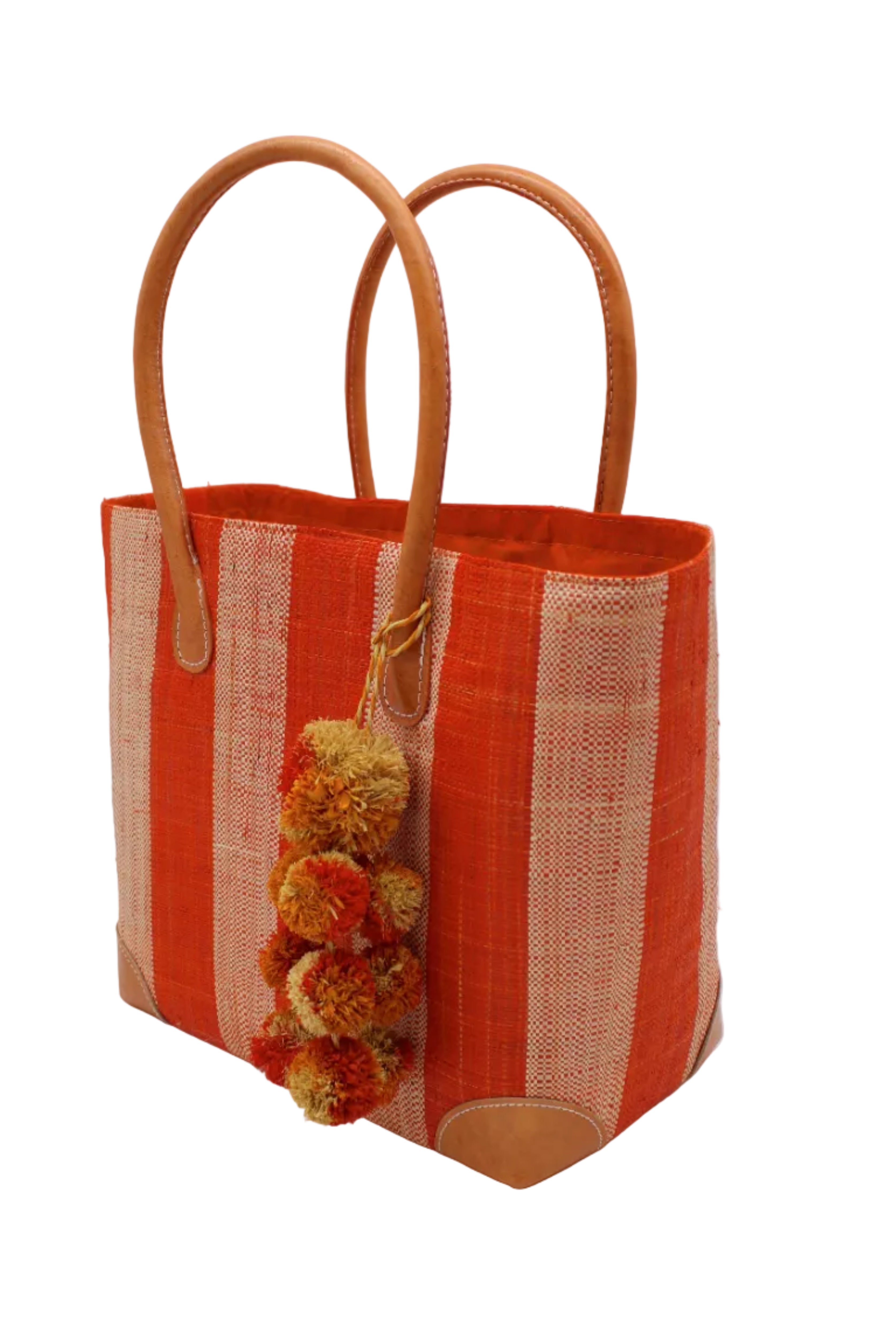 Side view Bora Bora Coral Two Tone Stripes Straw Basket Bag with Waterfall Pompoms Charm Embellishment handmade loomed natural raffia palm fiber in a multicolor horizontal stripe pattern of even width wide bands of coral orange/red and natural straw color with leather handles and feet plus matching waterfall pompom charm embellishment handbag beach bag - Shebobo