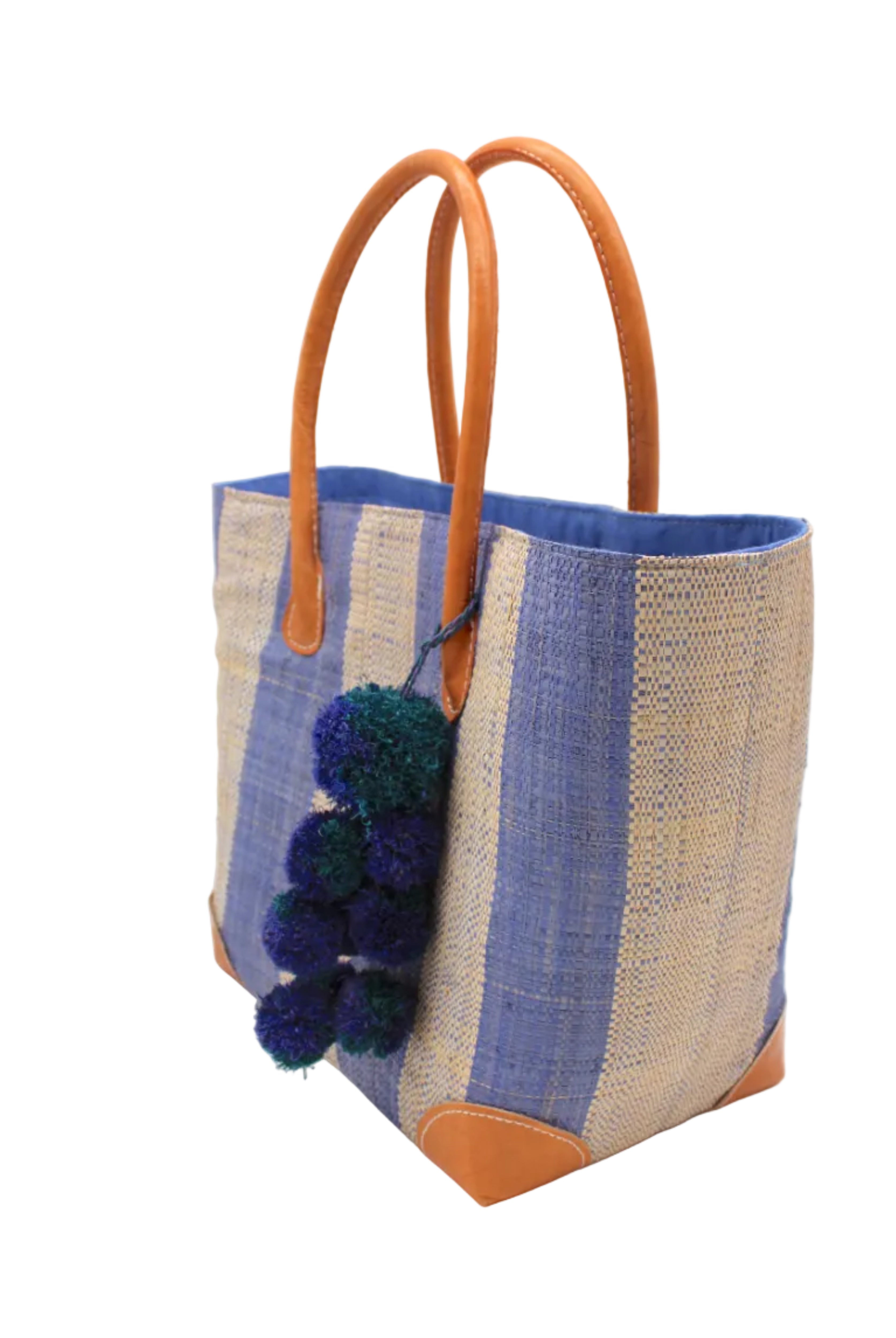 Side view Bora Bora Denim Two Tone Stripes Straw Basket Bag with Waterfall Pompoms Charm Embellishment handmade loomed natural raffia palm fiber in a multicolor horizontal stripe pattern of even width wide bands of denim retro/light/blue and natural straw color with leather handles and feet plus matching waterfall pompom charm embellishment handbag beach bag - Shebobo