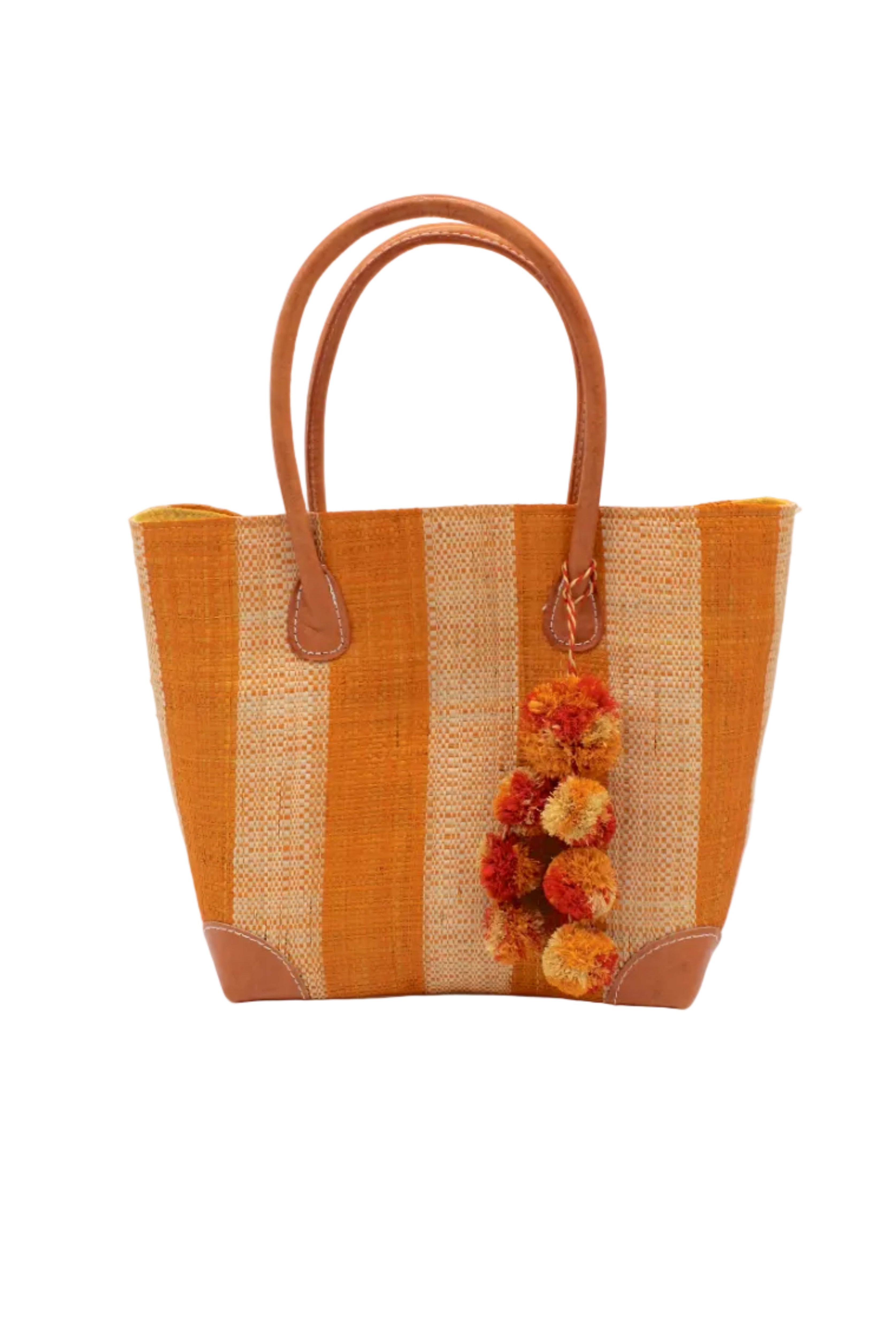 Bora Bora Saffron Two Tone Stripes Straw Basket Bag with Waterfall Pompoms Charm Embellishment handmade loomed natural raffia palm fiber in a multicolor horizontal stripe pattern of even width wide bands of saffron orange/yellow and natural straw color with leather handles and feet plus matching waterfall pompom charm embellishment handbag beach bag - Shebobo