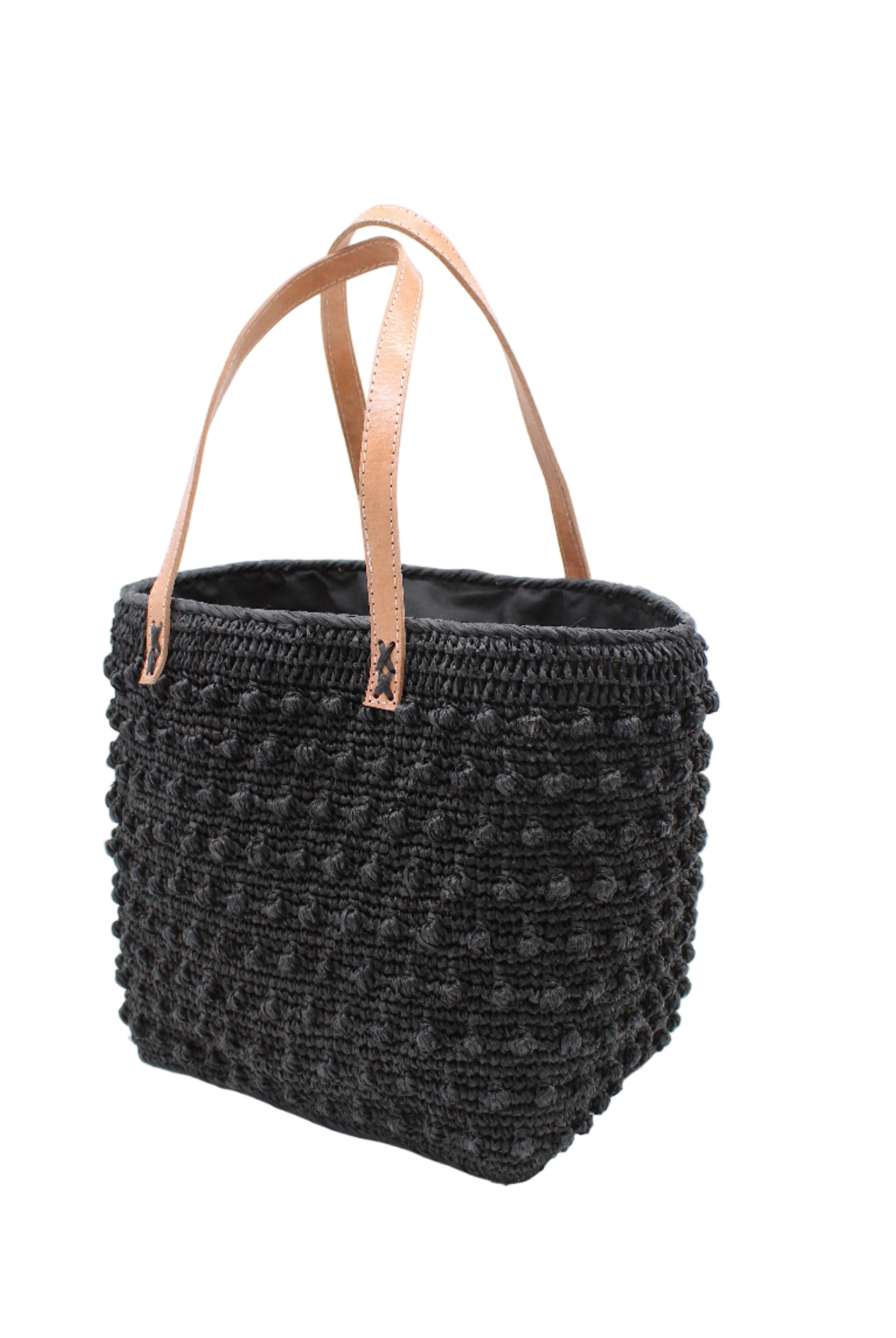 Side view Boucle Black Crochet Straw Basket Bag handmade woven raffia palm fiber in a solid hue of black in a supple nub/ball texture of horizontal bands around the bag with link weave around the top and loop crochet edging on the bottom and top plus leather handles beach bag shoulder bag purse - Shebobo