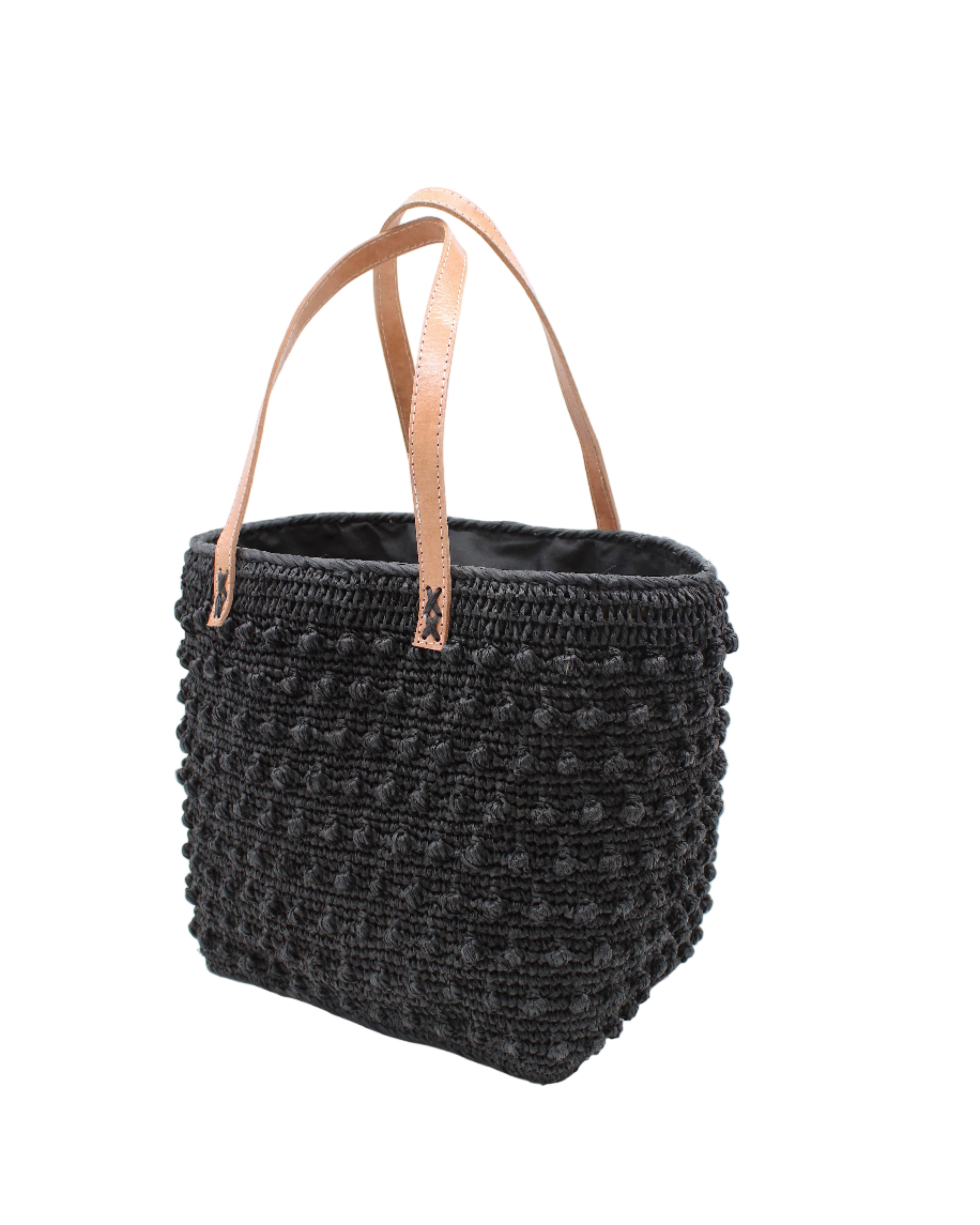 Side view Boucle Black Crochet Straw Basket Bag handmade woven raffia palm fiber in a solid hue of black in a supple nub/ball texture of horizontal bands around the bag with link weave around the top and loop crochet edging on the bottom and top plus leather handles beach bag shoulder bag purse - Shebobo