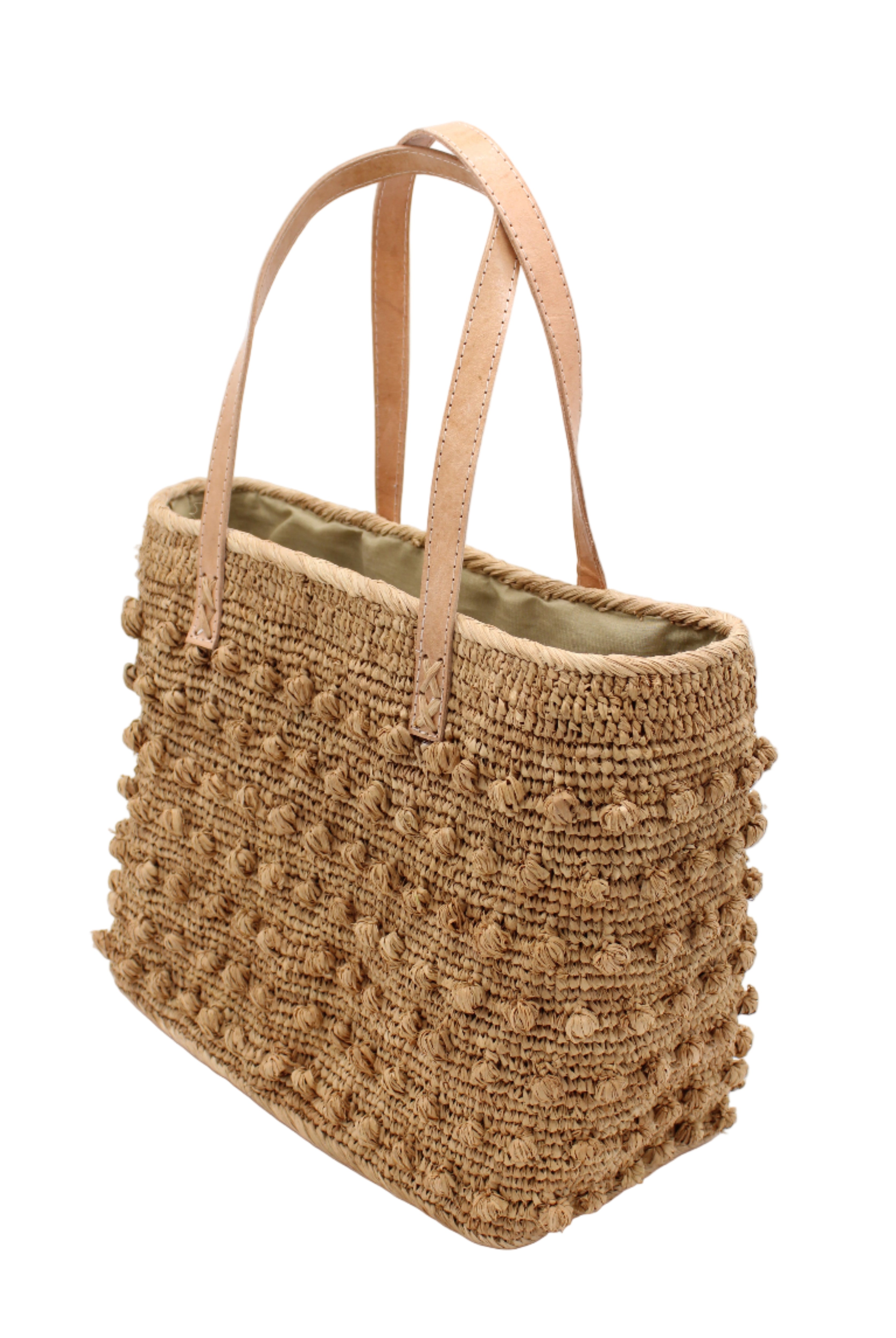 Side view Boucle Cappuccino Crochet Straw Basket Bag handmade woven raffia palm fiber in a solid hue of cappuccino tea/light/brown in a supple nub/ball texture of horizontal bands around the bag with link weave around the top and loop crochet edging on the bottom and top plus leather handles beach bag shoulder bag purse - Shebobo