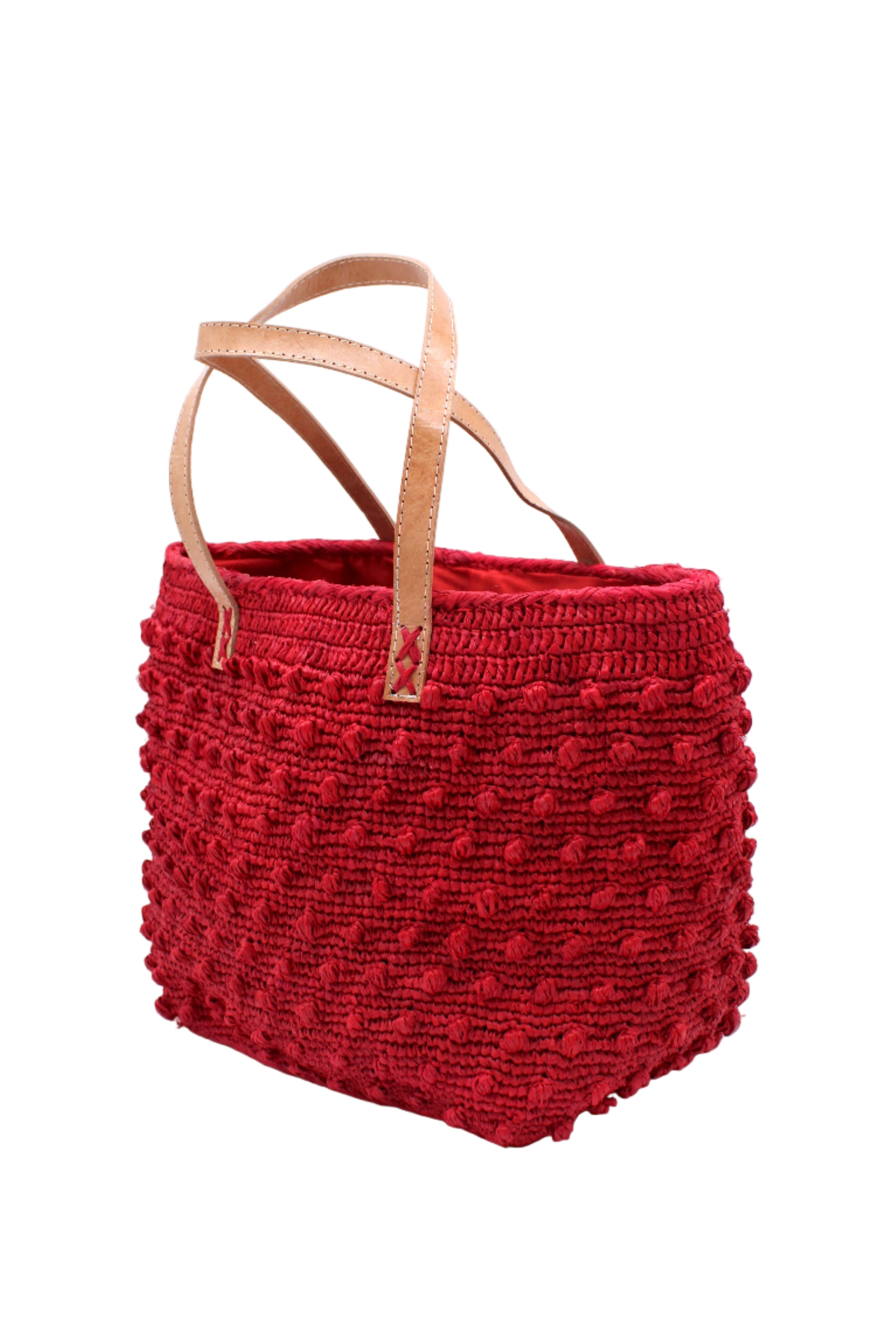 Side view Boucle Red Crochet Straw Basket Bag handmade woven raffia palm fiber in a solid hue of red in a supple nub/ball texture of horizontal bands around the bag with link weave around the top and loop crochet edging on the bottom and top plus leather handles beach bag shoulder bag purse - Shebobo