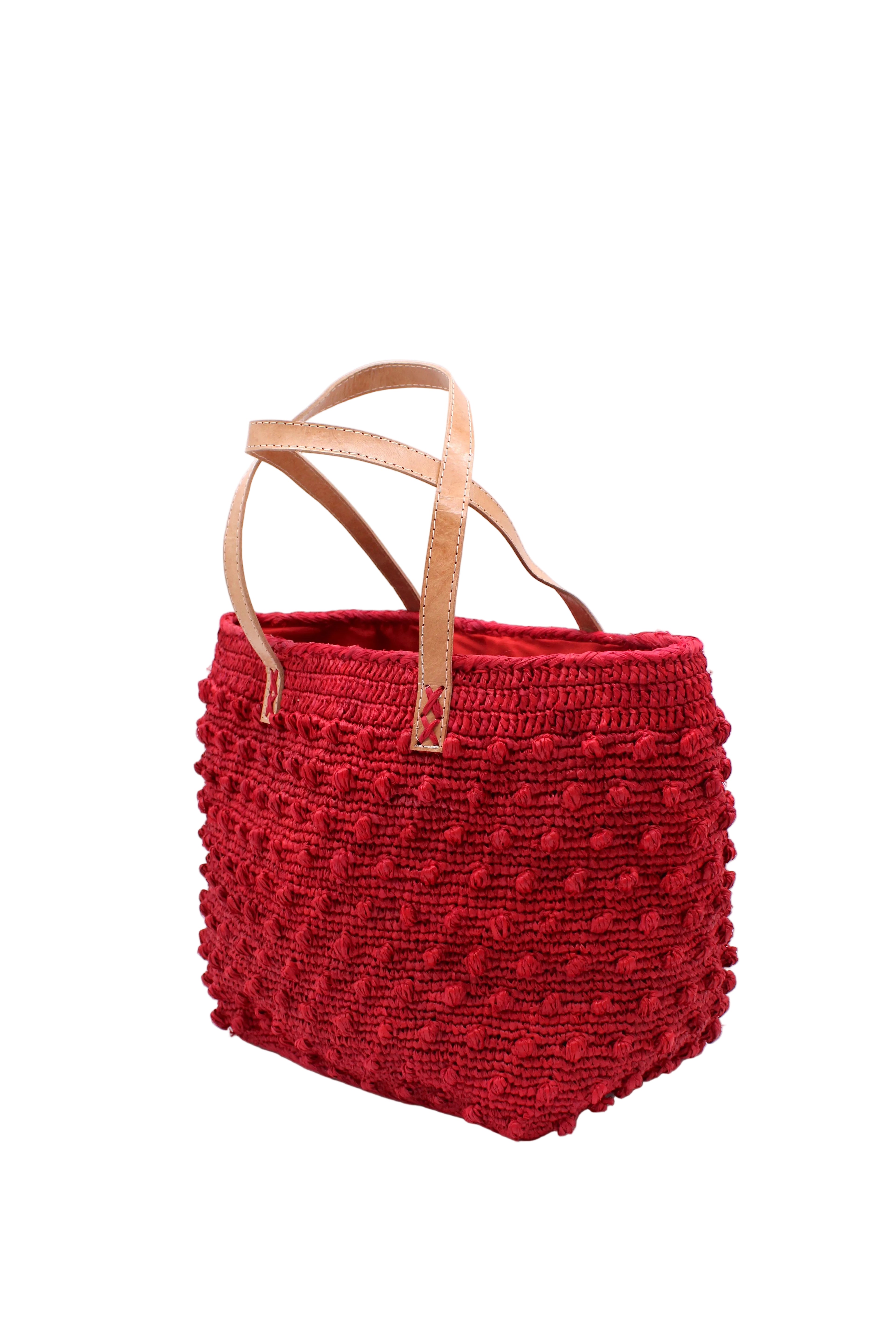 Side view Boucle Red Crochet Straw Basket Bag handmade woven raffia palm fiber in a solid hue of red in a supple nub/ball texture of horizontal bands around the bag with link weave around the top and loop crochet edging on the bottom and top plus leather handles beach bag shoulder bag purse - Shebobo