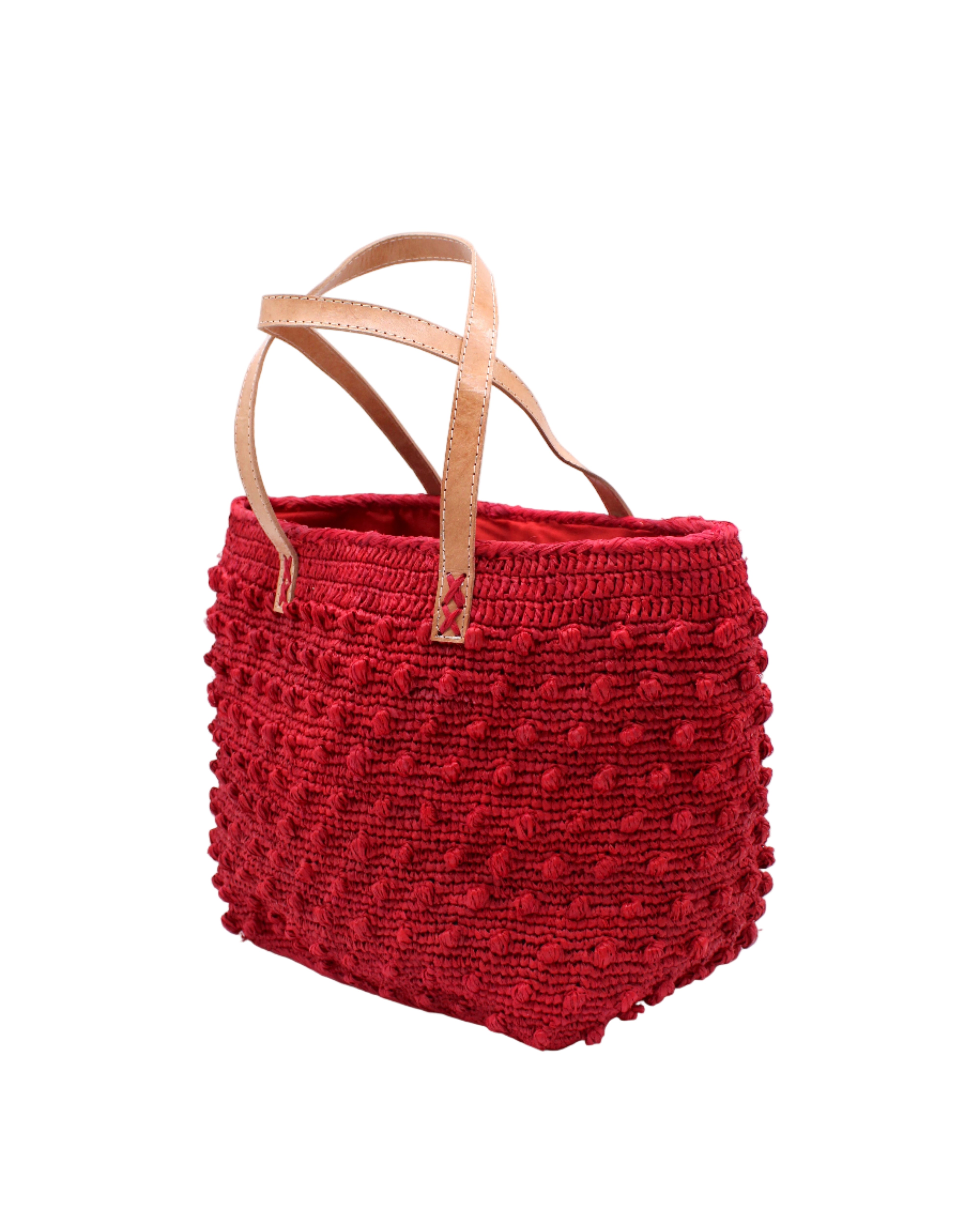 Side view Boucle Red Crochet Straw Basket Bag handmade woven raffia palm fiber in a solid hue of red in a supple nub/ball texture of horizontal bands around the bag with link weave around the top and loop crochet edging on the bottom and top plus leather handles beach bag shoulder bag purse - Shebobo