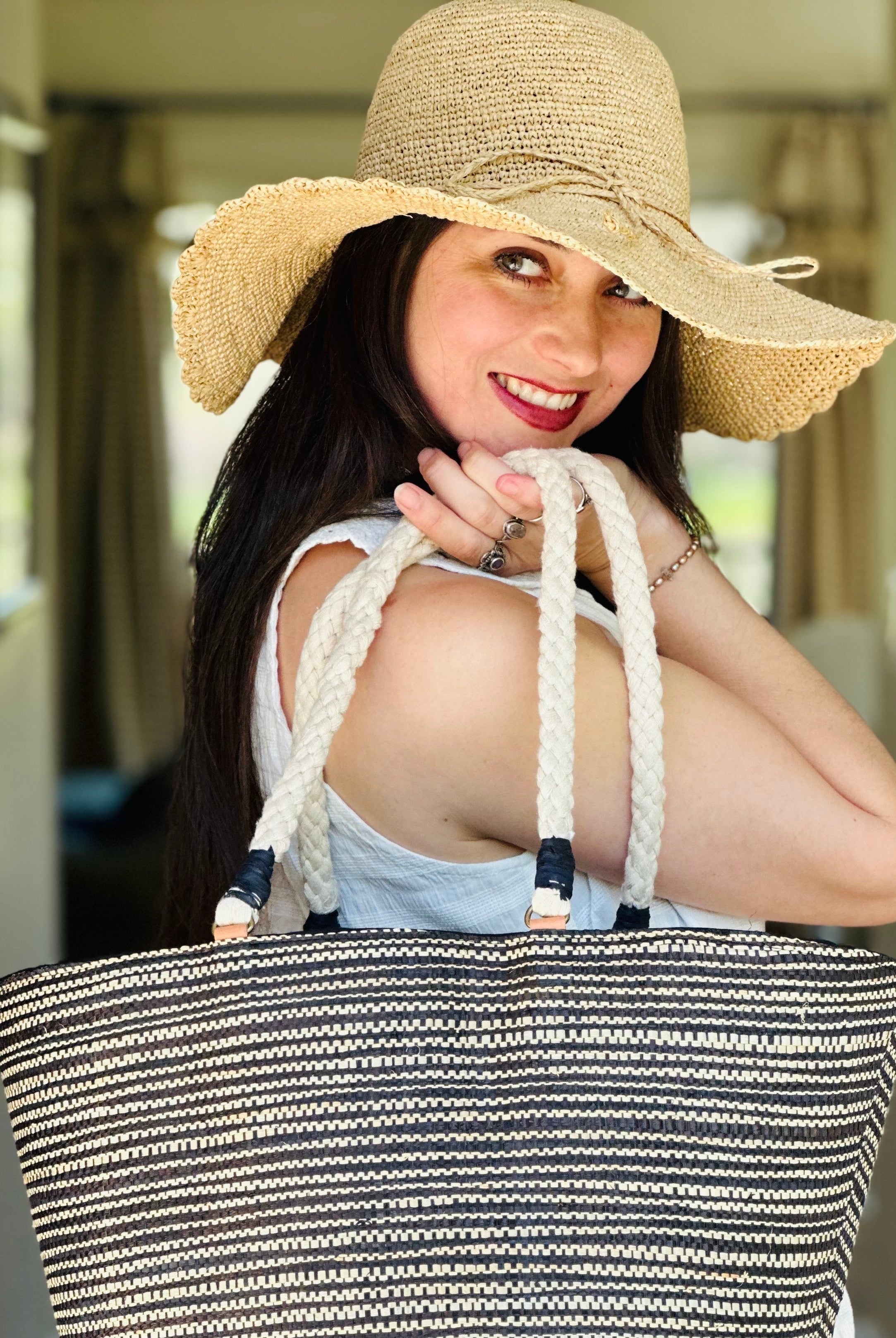 Model wearing 4" Brim Genevieve Natural Crochet Straw Sun Hat with Lace Weave Edge handmade raffia palm fiber crochet solid hue natural straw color rounded crown with detailed lace weave edge and matching adjustable hat band with Brighton Black Two Tone Multi Melange Straw Beach Tote Bag with Rope Handle - Shebobo