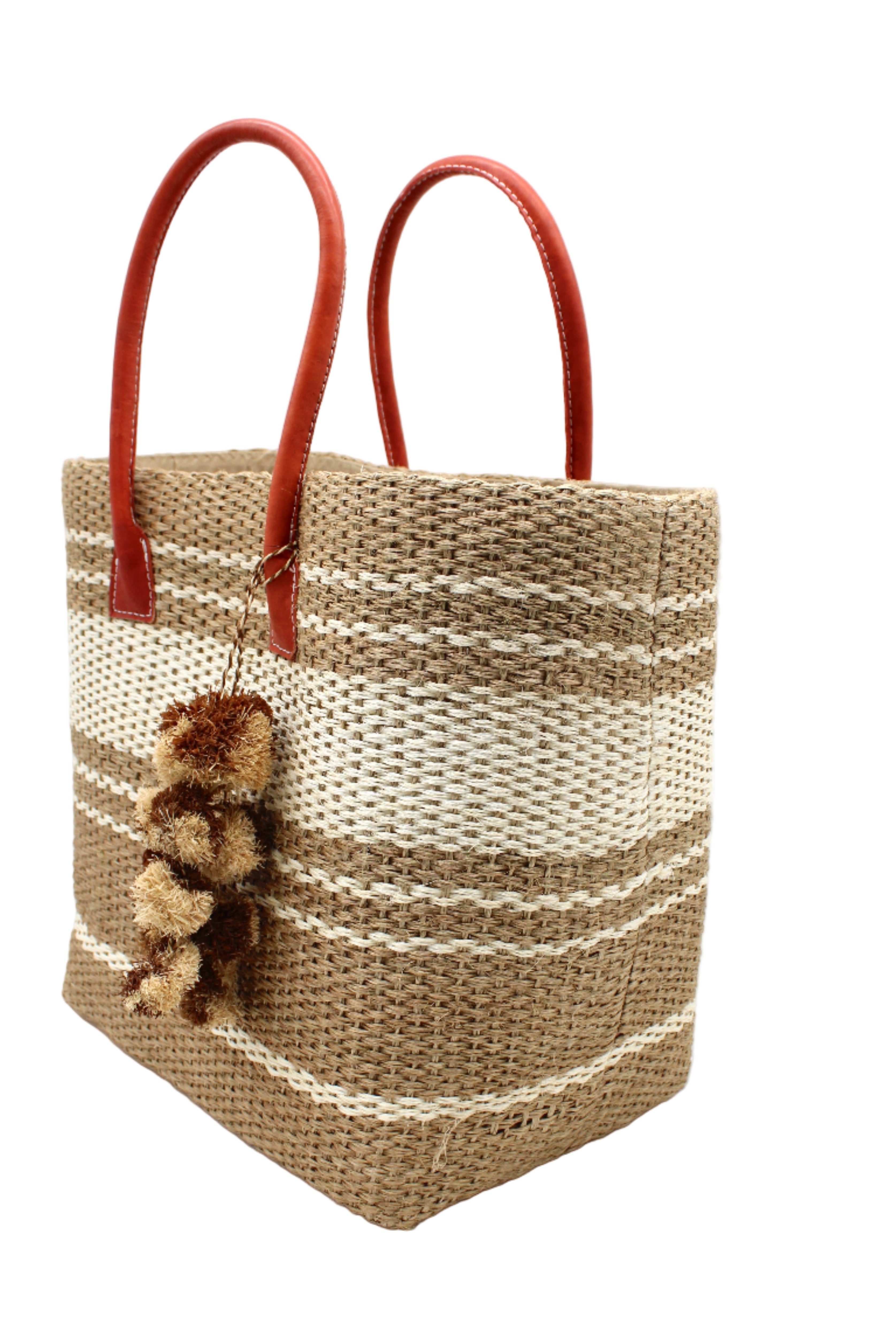 Side view Cabrillo Sisal Basket Bag with Waterfall Pompoms Charm Embellishment handmade natural sisal fiber woven into a multicolor two tone Cappuccino tea/light/brown and natural straw color horizontal stripe pattern with muti-width bands of color plus leather handles and two tone raffia charm shoulder bag beach bag - Shebobo