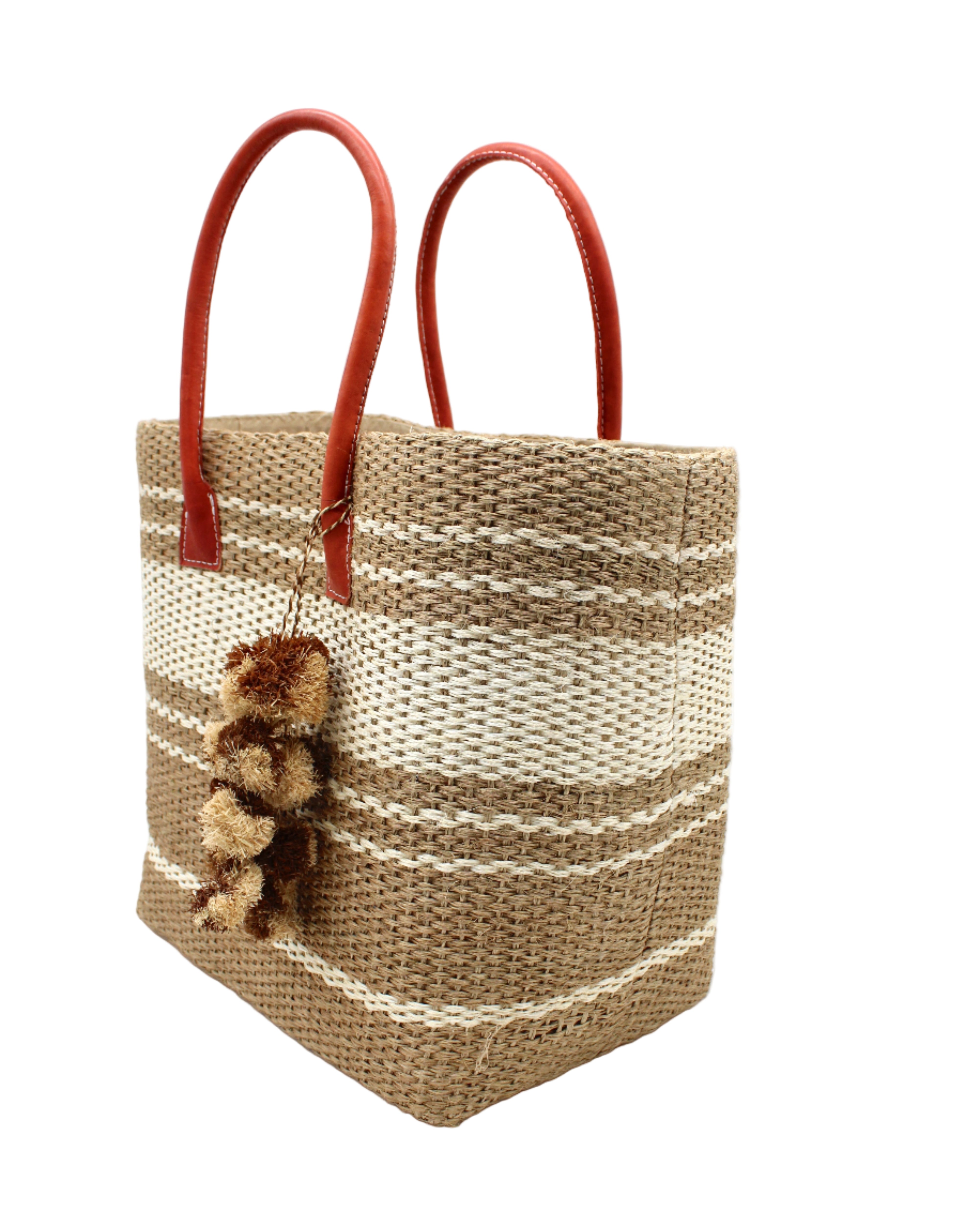 Side view Cabrillo Sisal Basket Bag with Waterfall Pompoms Charm Embellishment handmade natural sisal fiber woven into a multicolor two tone Cappuccino tea/light/brown and natural straw color horizontal stripe pattern with muti-width bands of color plus leather handles and two tone raffia charm shoulder bag beach bag - Shebobo
