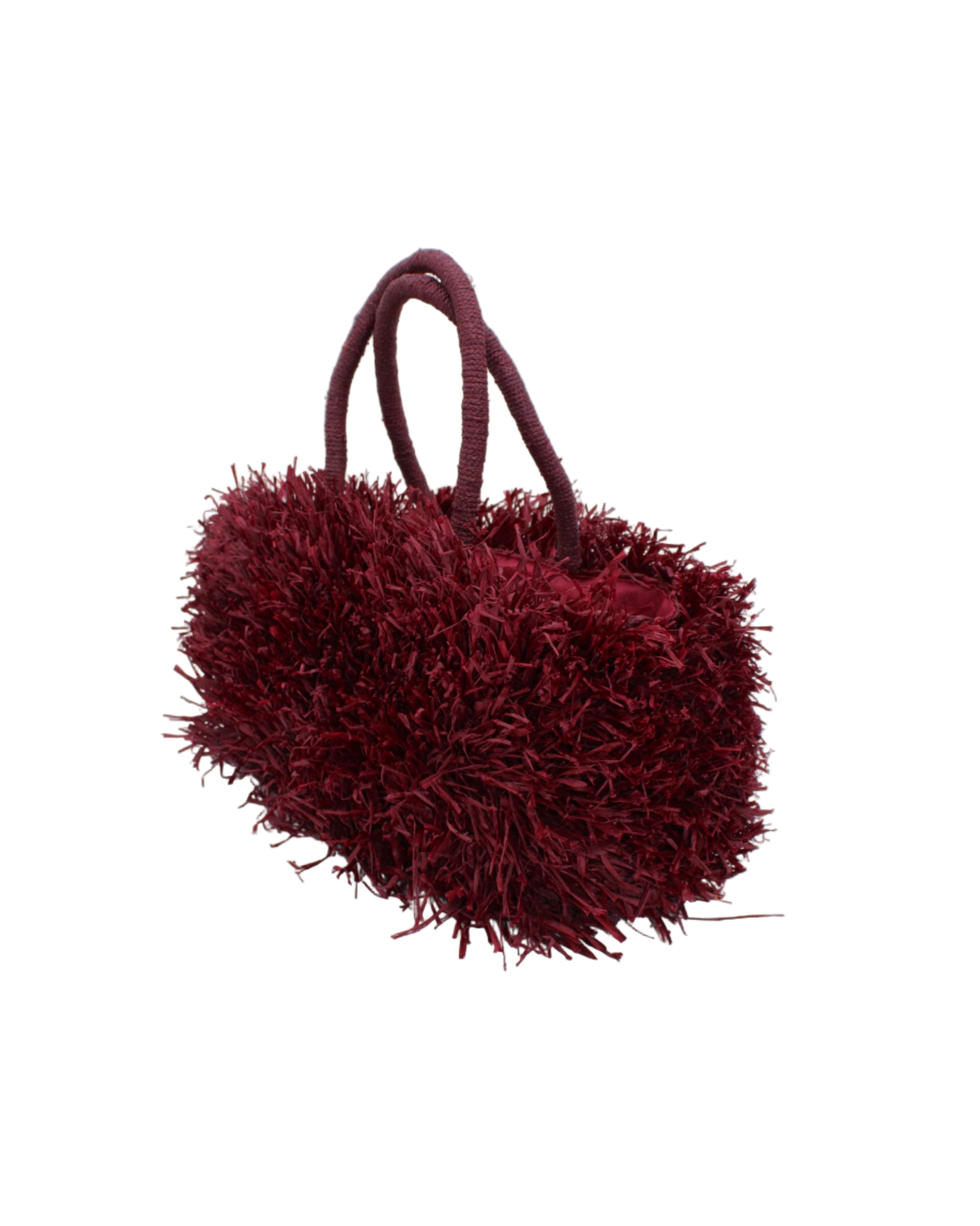 Side view Calypso Pompom Pouf Crochet Straw Basket Handbag handmade natural raffia palm fiber in a solid hue of Umberwine burgunday/bordeaux/dark/purple/red with brushed fringe strands crochet and knotted into a pouf texture with matching wrapped handles purse - Shebobo