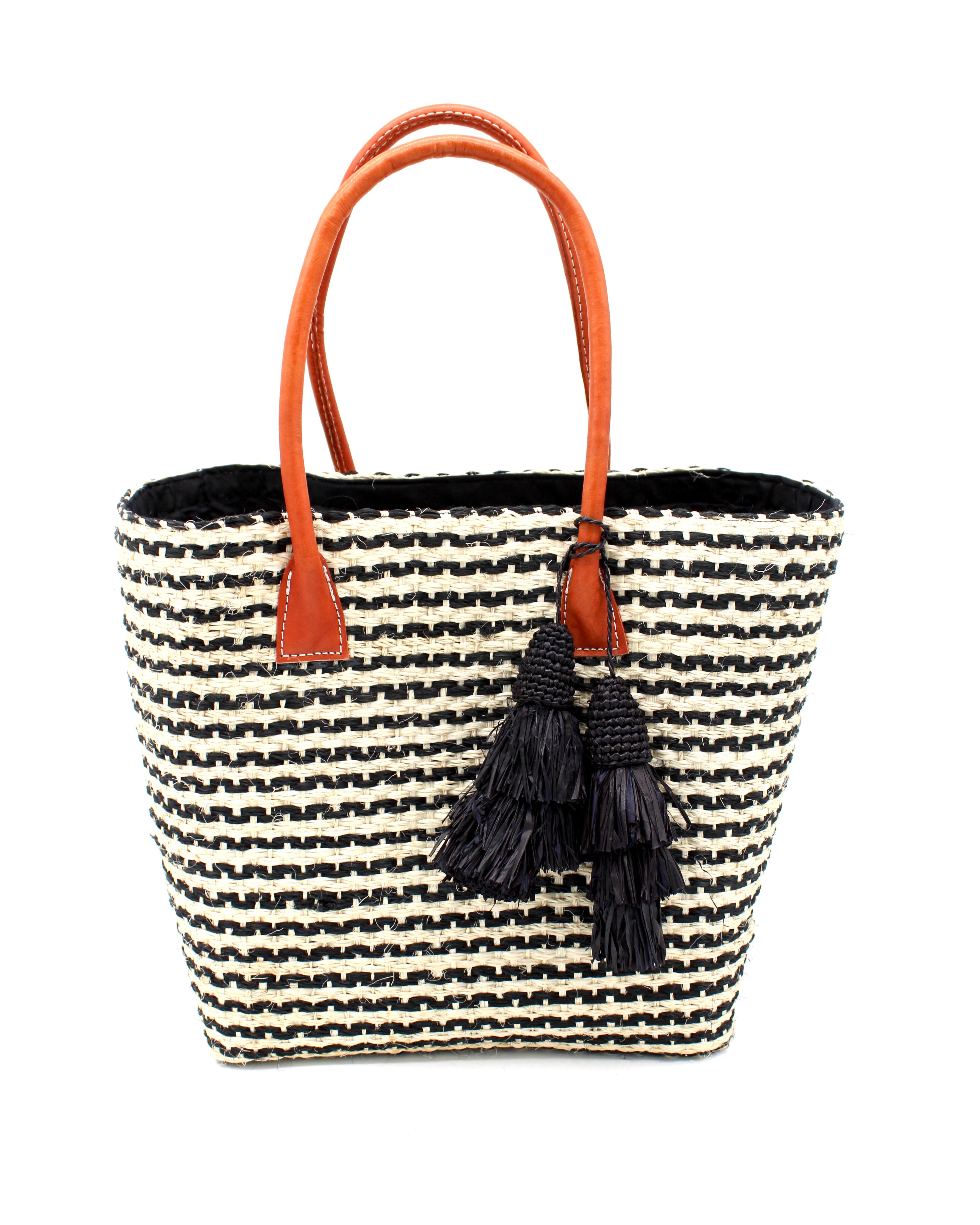 Cancun Small Sisal Basket Bag with Tassel Charm handmade natural sisal fibers woven into even width horizontal bands of black and natural straw color that create a pinstripe pattern with matching knotted raffia tufts tassel charm embellishment and leather handles beach bag - Shebob