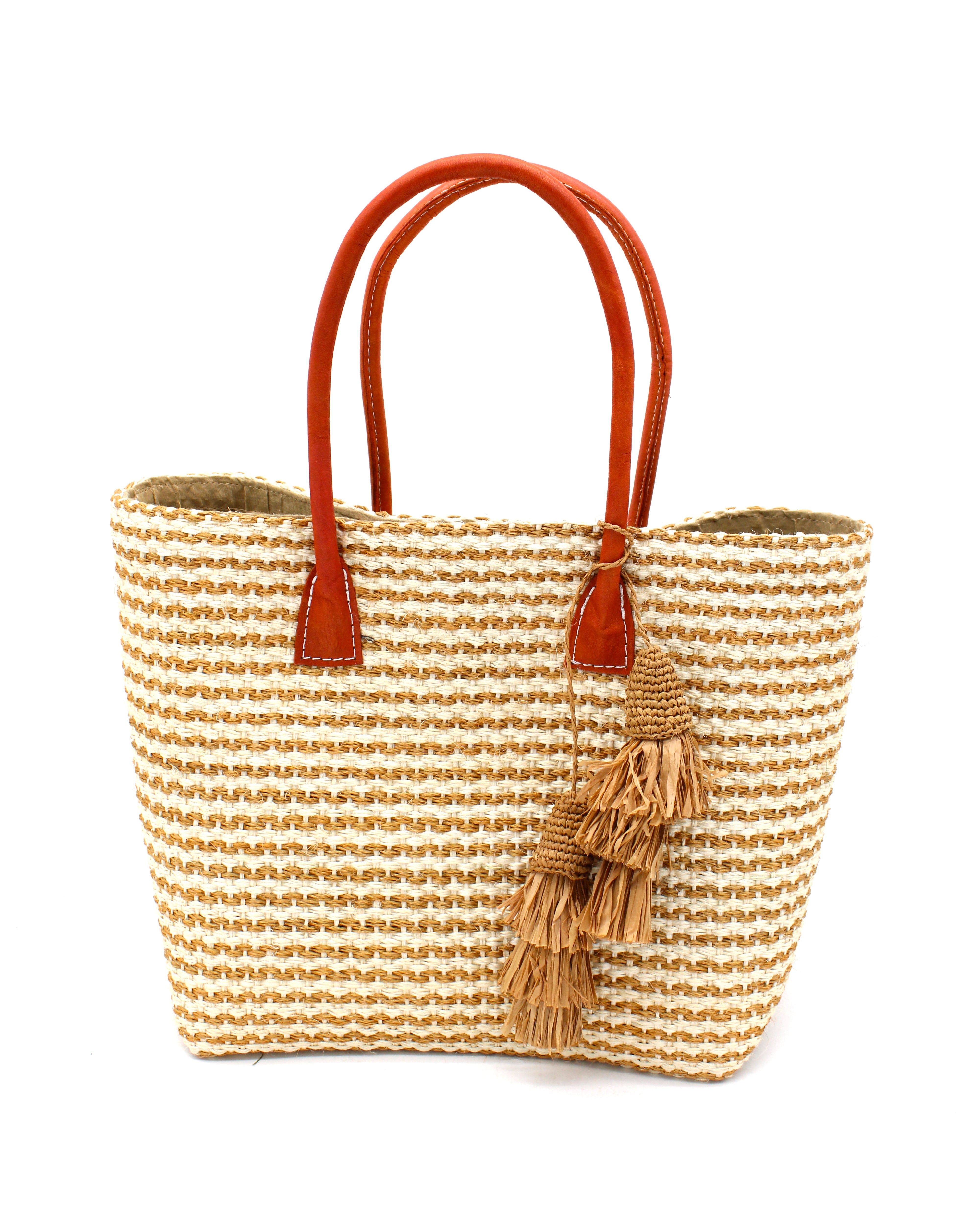 Cancun Small Sisal Basket Bag with Tassel Charm handmade natural sisal fibers woven into even width horizontal bands of cappuccino light brown and natural straw color that create a pinstripe pattern with matching knotted raffia tufts tassel charm embellishment and leather handles beach bag - Shebob