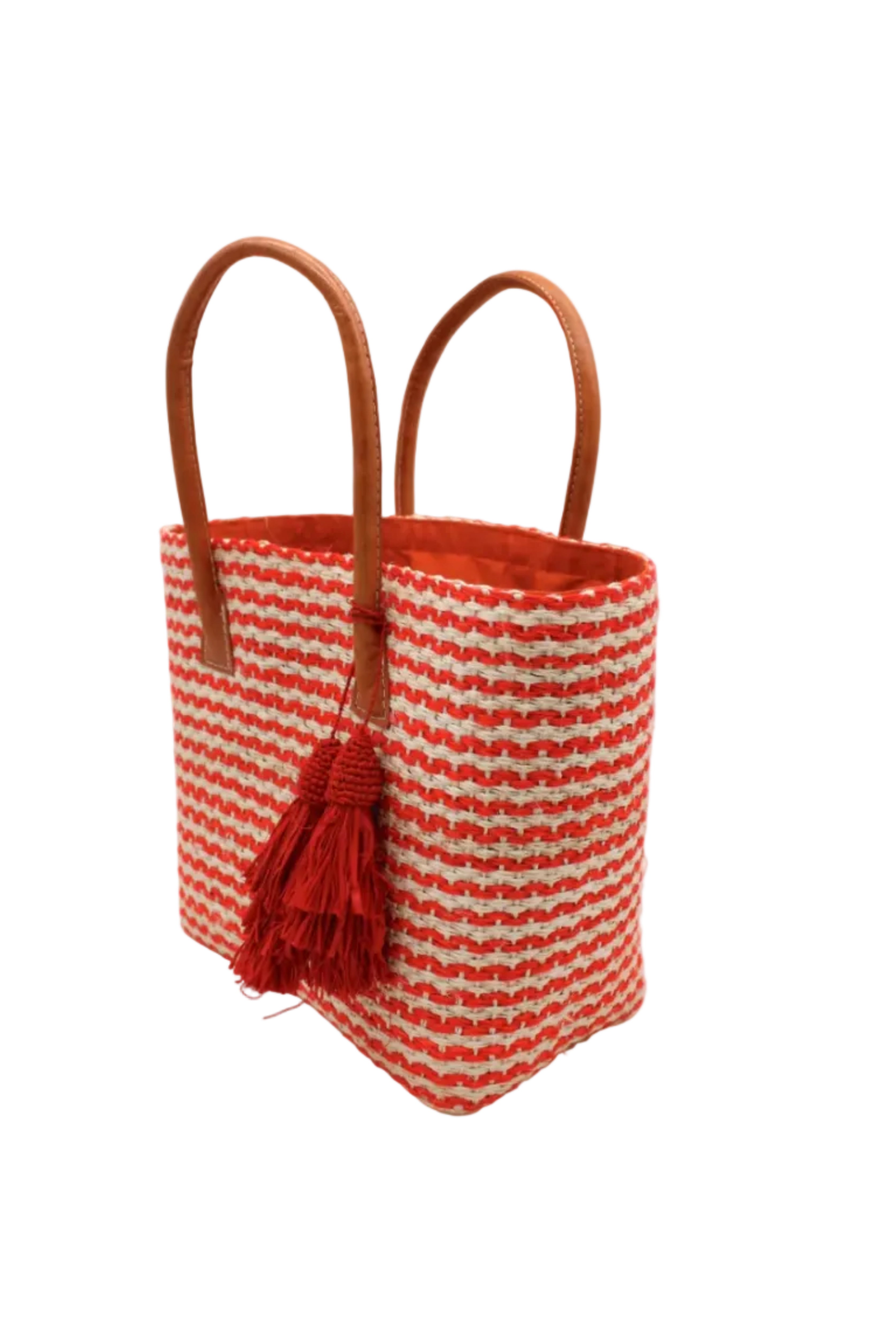 Side view Cancun Small Sisal Basket Bag with Tassel Charm handmade natural sisal fibers woven into even width horizontal bands of coral orange and natural straw color that create a pinstripe pattern with matching knotted raffia tufts tassel charm embellishment and leather handles beach bag - Shebobo