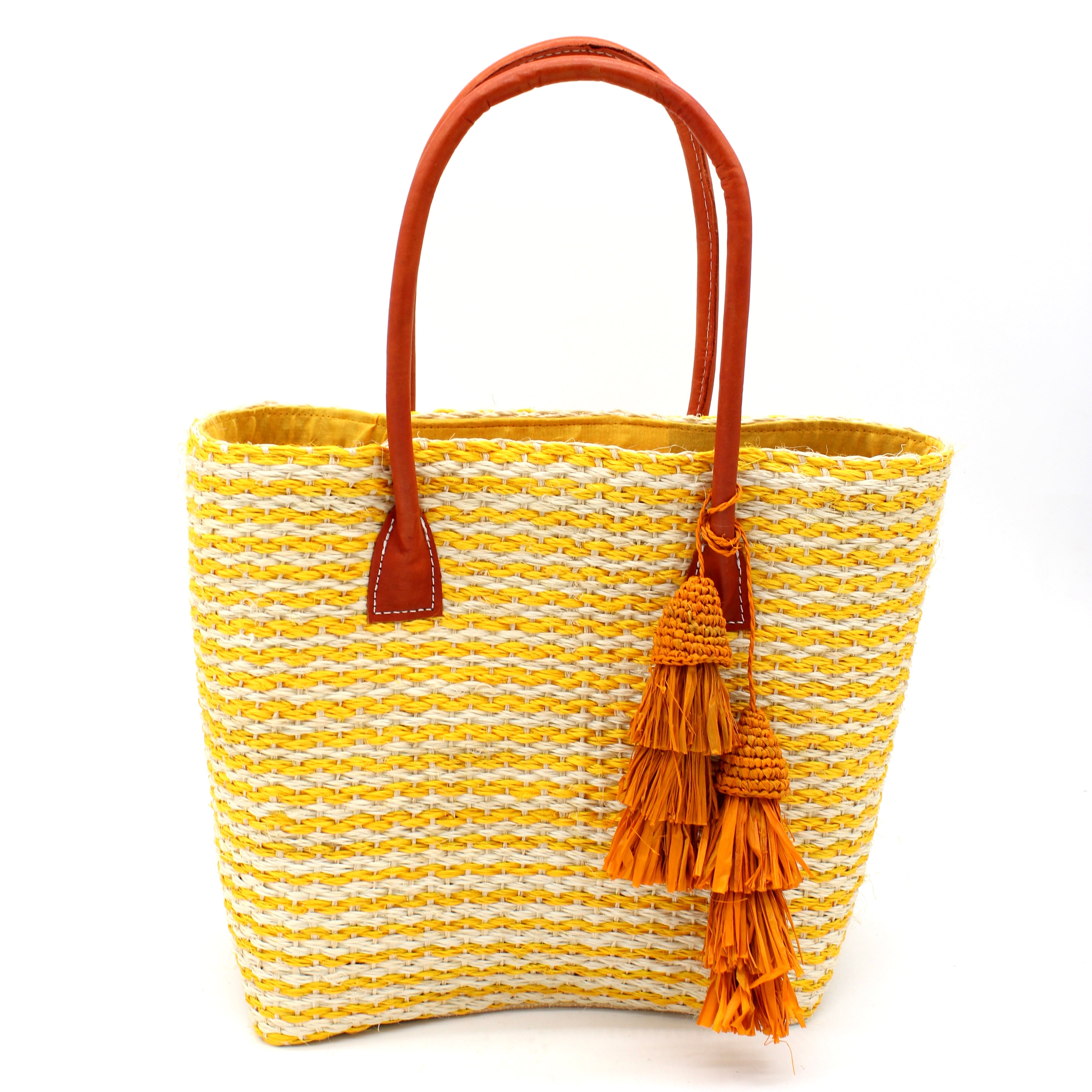 Cancun Small Sisal Basket Bag with Tassel Charm handmade natural sisal fibers woven into even width horizontal bands of saffron yellow and natural straw color that create a pinstripe pattern with matching knotted raffia tufts tassel charm embellishment and leather handles beach bag - Shebob