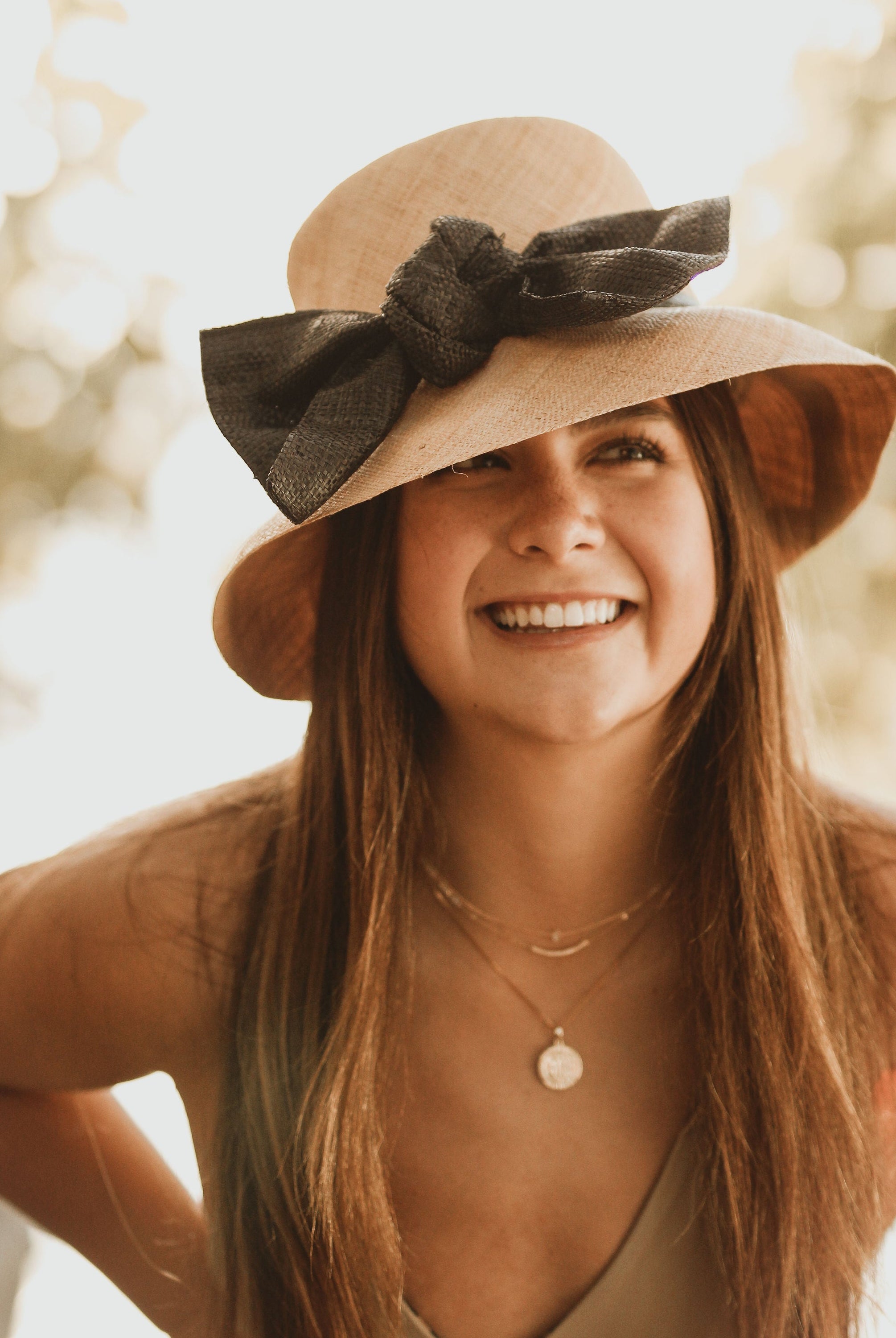 Model Wearing Cara Big Bow Straw Hat Handmade loomed raffia straw hat solid natural bucket hat with large black bow - Shebobo