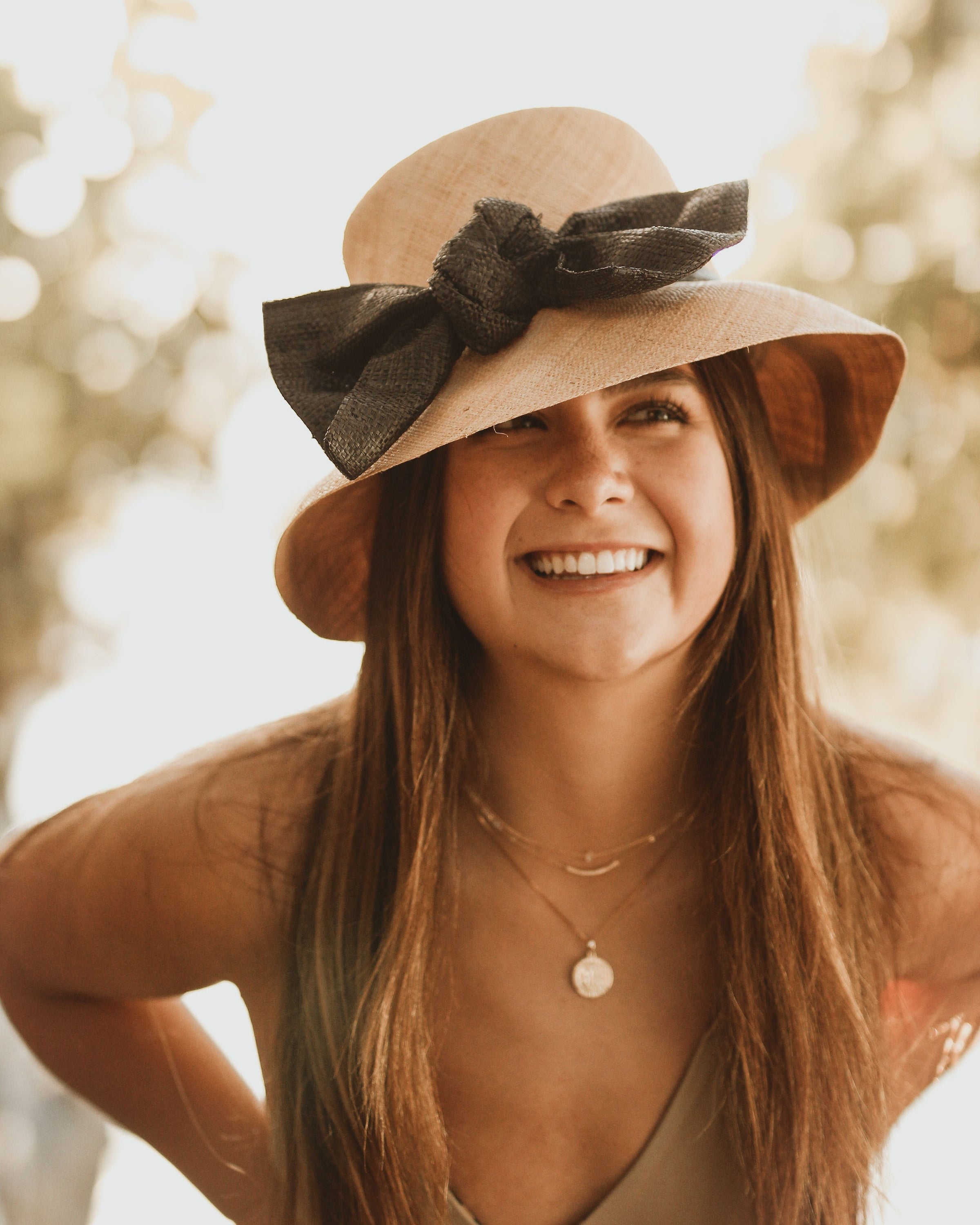 Model Wearing Cara Big Bow Straw Hat Handmade loomed raffia straw hat solid natural bucket hat with large black bow - Shebobo