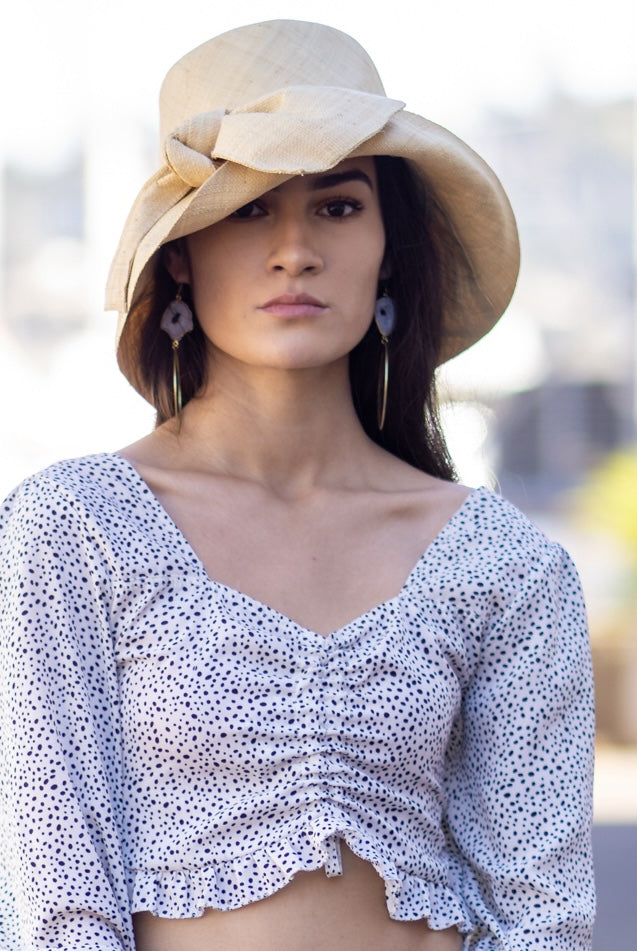 Model wearing Cara Natural straw color big bow embellishment handmade loomed raffia straw bucket style cloche sun hat - Shebobo