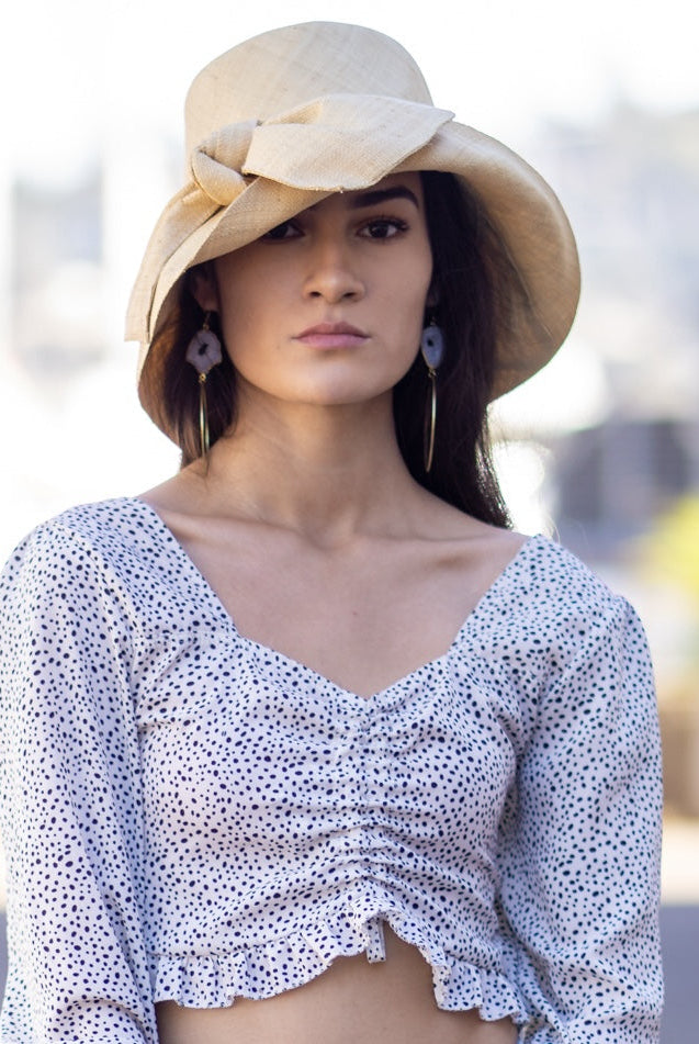 Model wearing Cara Natural straw color big bow embellishment handmade loomed raffia straw bucket style cloche sun hat - Shebobo